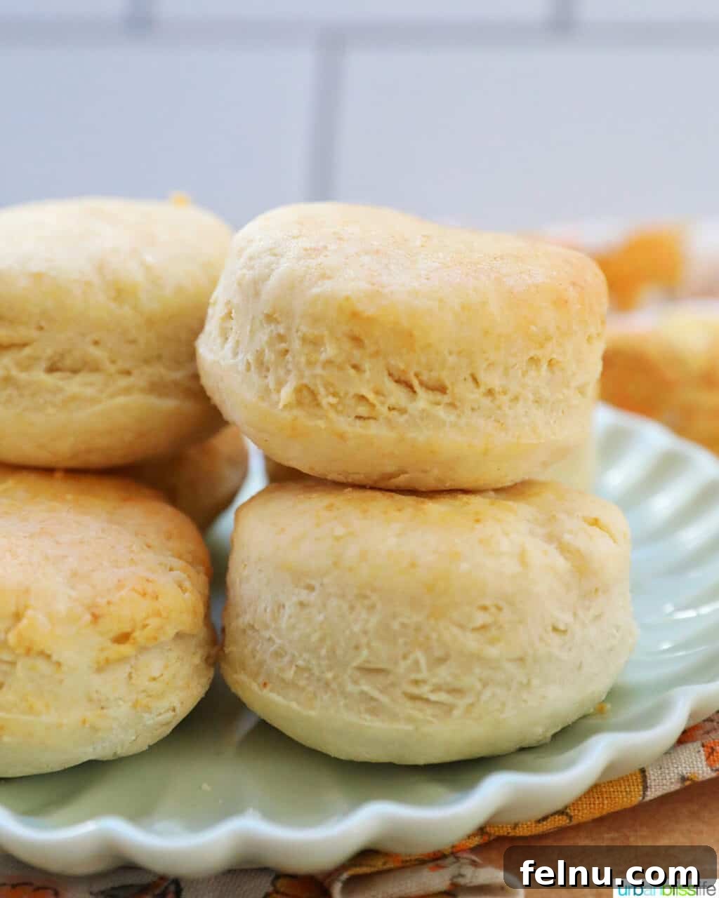 Fluffy Air Fryer Biscuits 3 air fryer biscuits stacked on a plate, side view showing layers.