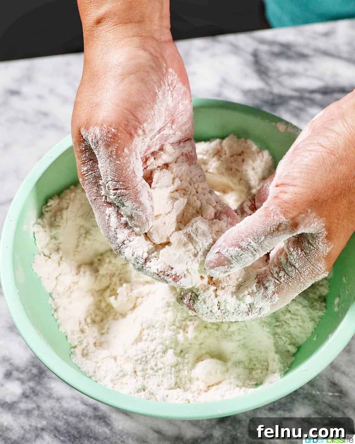Fluffy Air Fryer Biscuits 6 hands cutting cold butter into biscuit dough.
