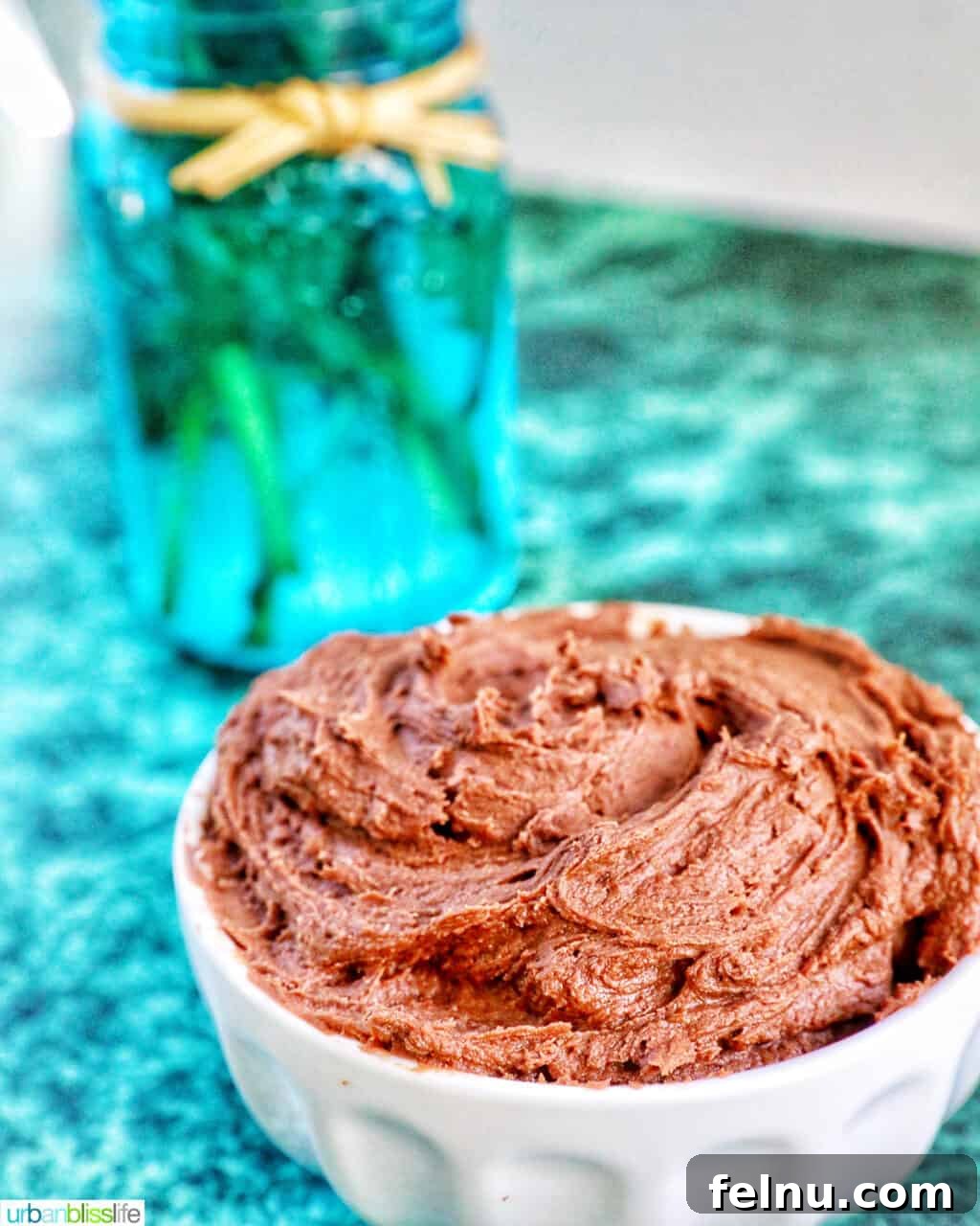 Effortless Decadent Chocolate Buttercream 2 A bowl of fluffy, creamy chocolate buttercream frosting on a green marble table, ready to be enjoyed.