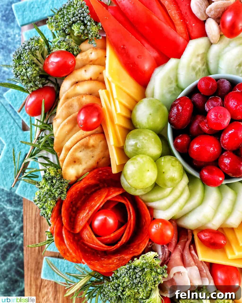 A Festive Christmas Snack Board 3 Close-up of a Christmas charcuterie board showcasing the left side with an assortment of meats, cheeses, fruits, and vegetables.