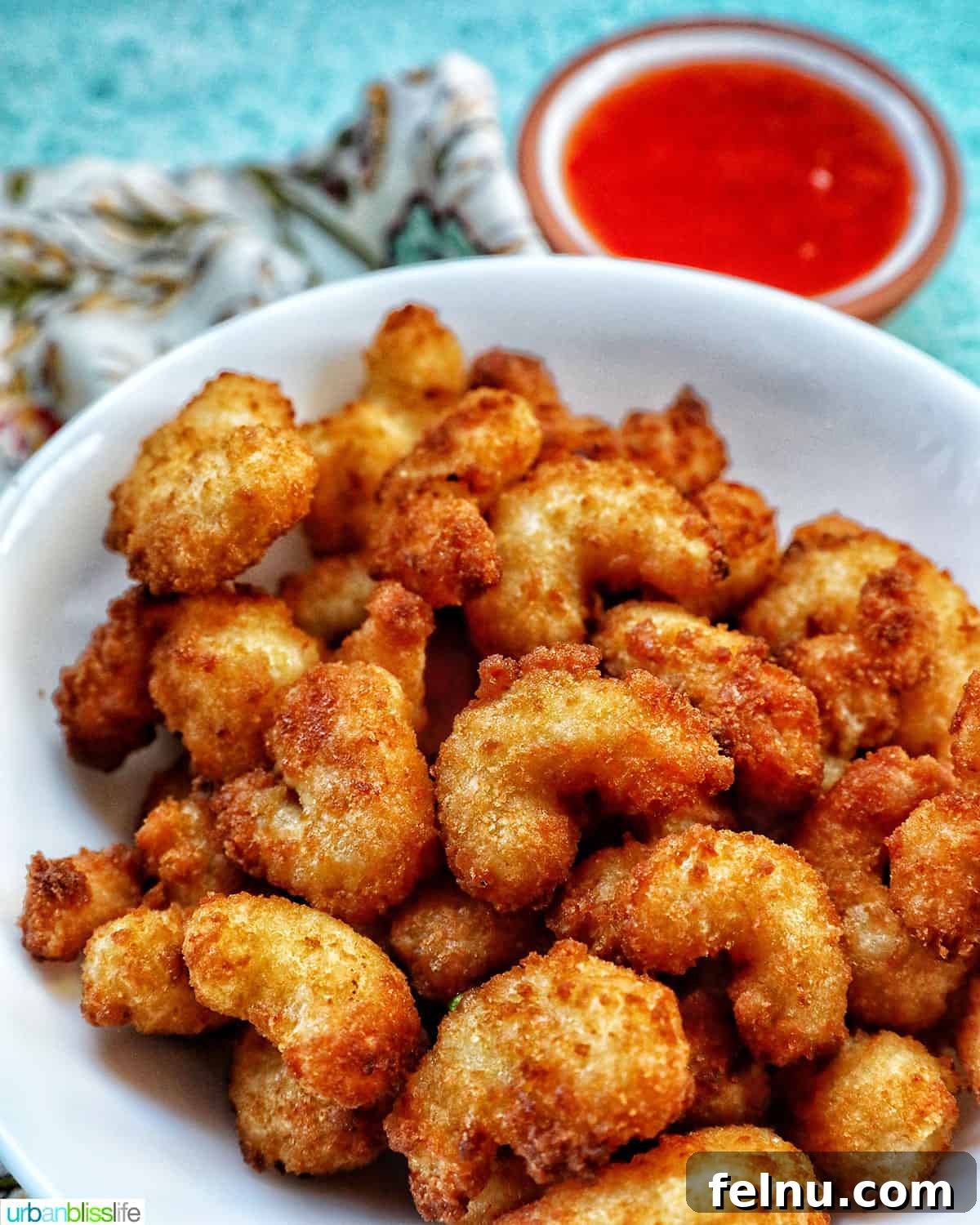 Crispy Air Fryer Popcorn Shrimp 2 Crispy air fryer popcorn shrimp served on a plate with a side of zesty cocktail sauce, ready to be enjoyed.