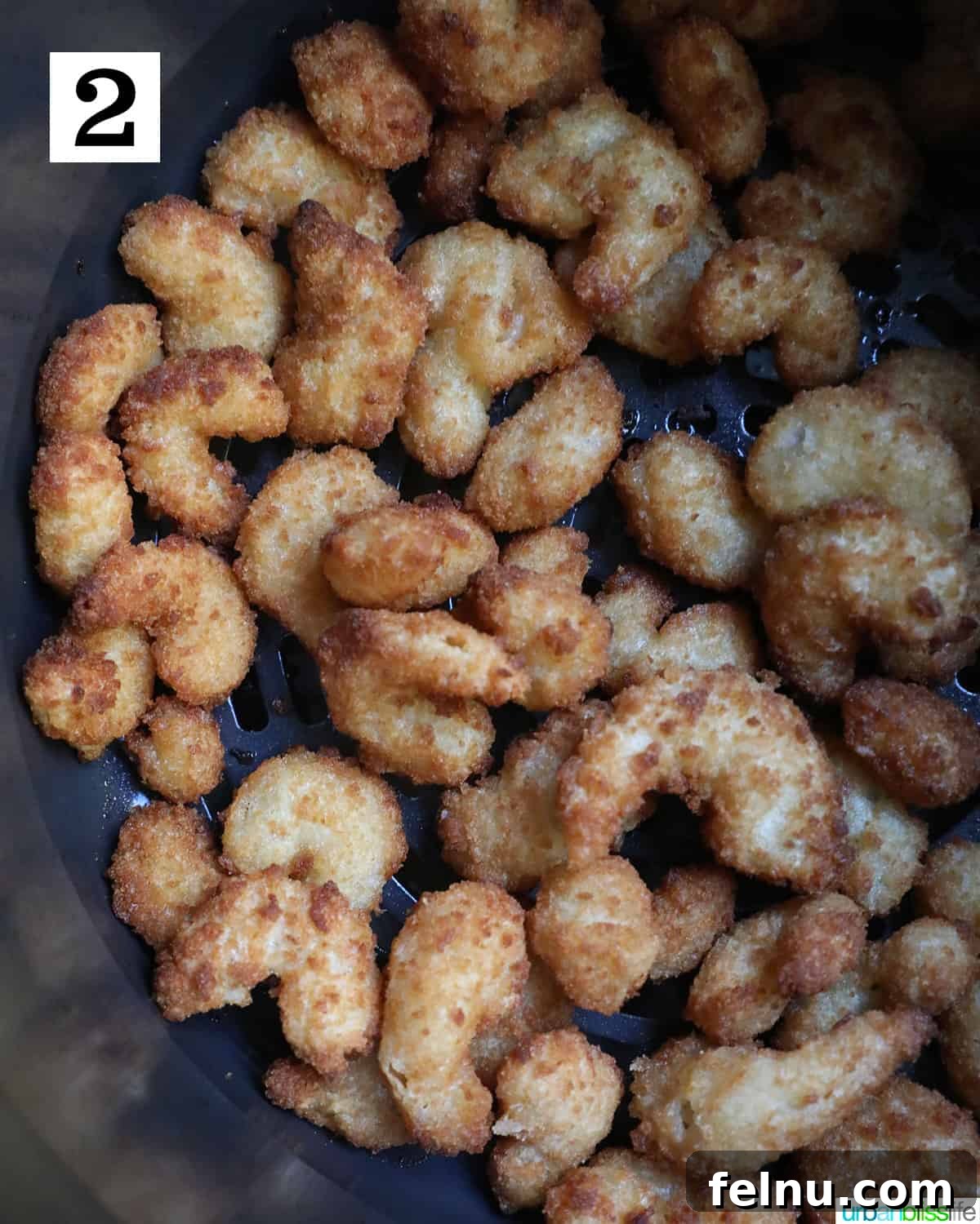 Crispy Air Fryer Popcorn Shrimp 6 Arranging frozen popcorn shrimp in a single layer within the air fryer basket, ensuring even cooking and optimal crisping.