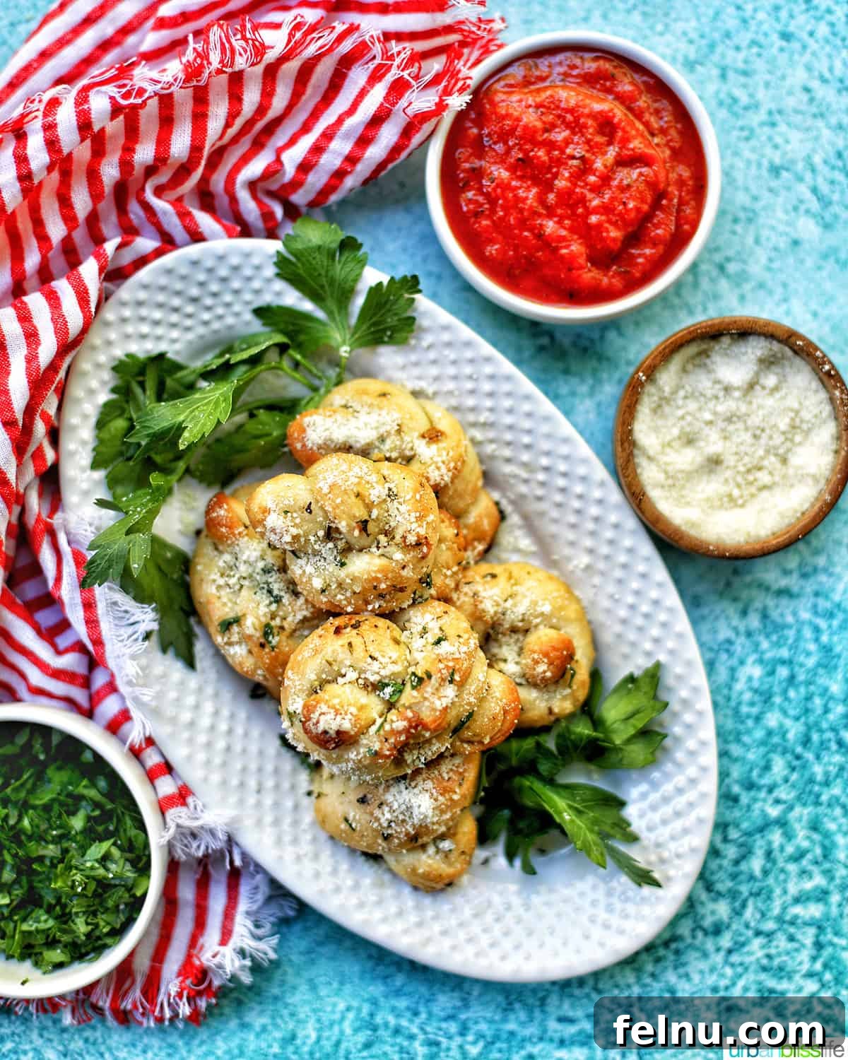 Upgrade Your Pizza Night: 25 Mouthwatering Side Dishes 2 Delicious garlic knots on a white plate with marinara dipping sauce, a perfect complement to pizza.
