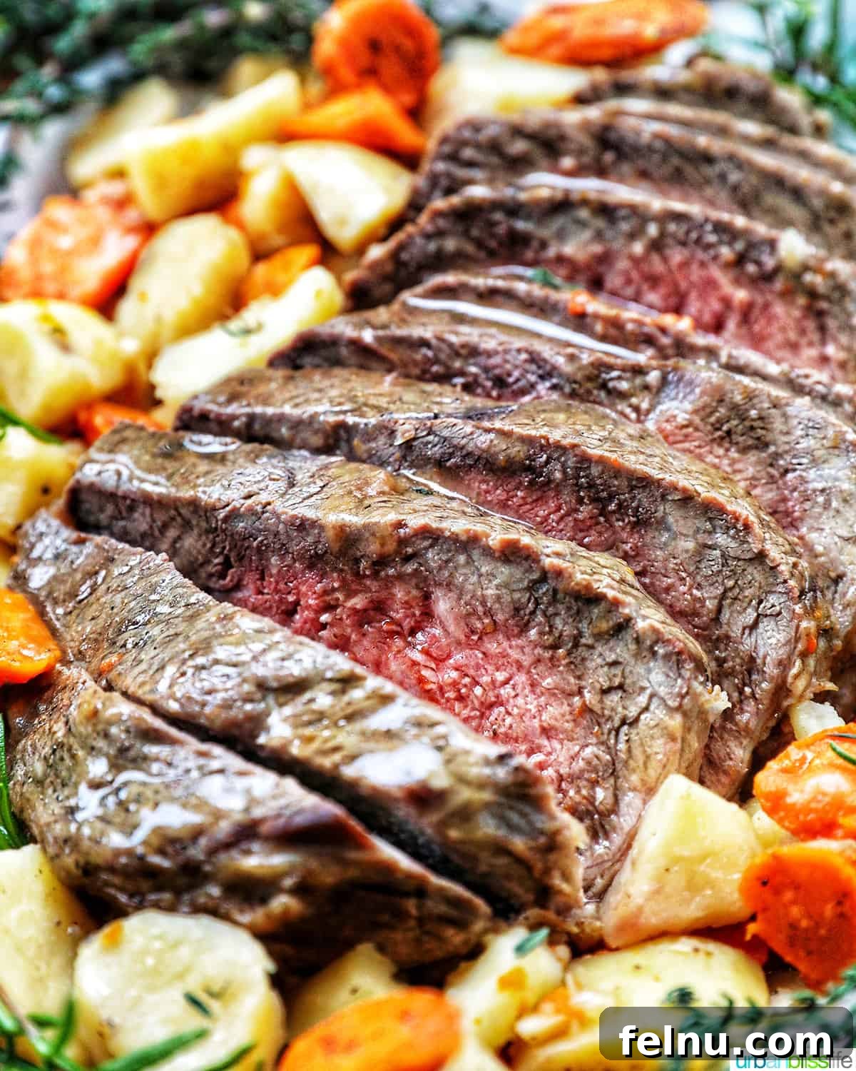 Tender Instant Pot Sirloin Tip Roast 19 Sliced sirloin tip roast surrounded by carrots, potatoes, and herbs.