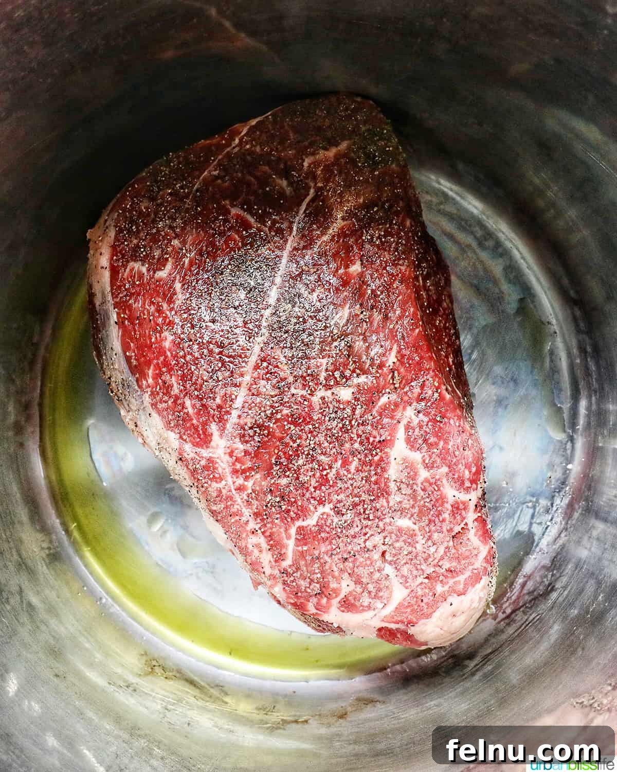Tender Instant Pot Sirloin Tip Roast 7 seasoned sirloin beef roast in the Instant Pot with olive oil, searing.