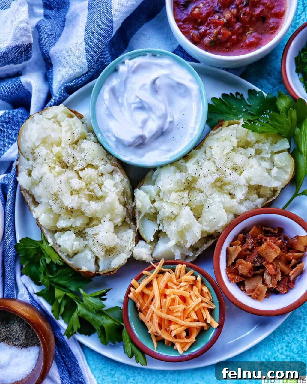 Crispy Fluffy Ninja Foodi Air Fryer Baked Potatoes 2 Loaded air fryer baked potato with title text overlay and sides of sour cream, cheddar cheese, parsley, and bacon.