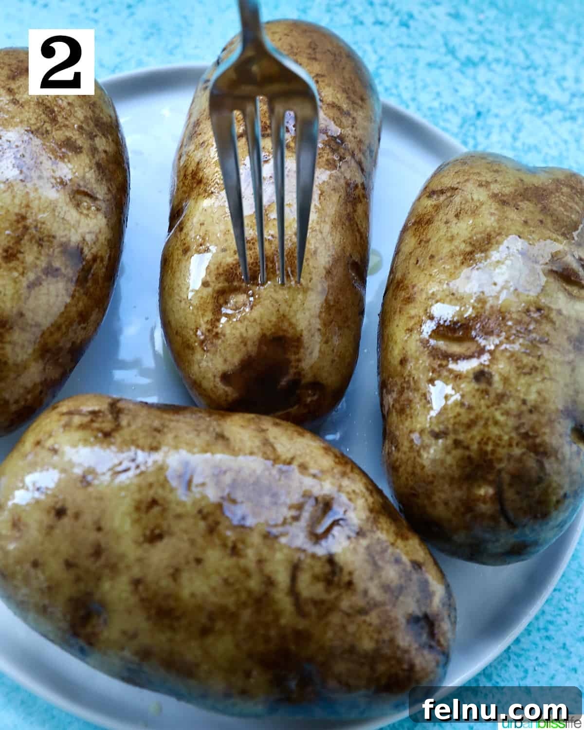 Crispy Fluffy Ninja Foodi Air Fryer Baked Potatoes 6 fork piercing baked potatoes.