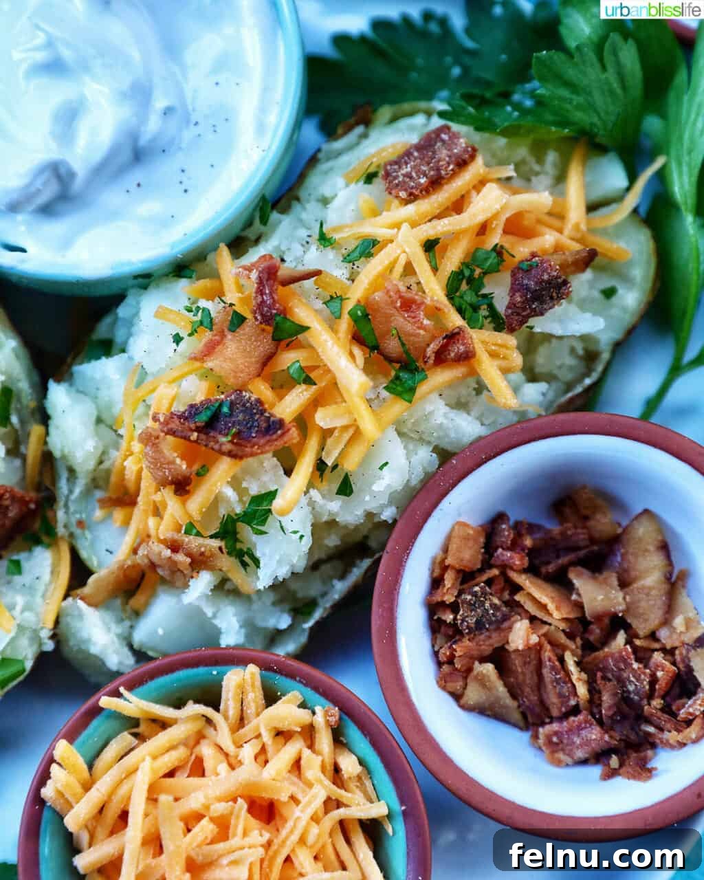 Crispy Fluffy Ninja Foodi Air Fryer Baked Potatoes 10 Loaded air fryer baked potato with title text overlay and sides of sour cream, cheddar cheese, parsley, and bacon.