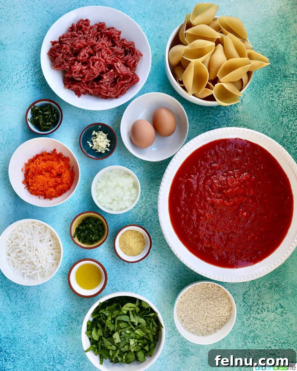 Hearty Dairy-Free Beef Stuffed Shells 4 Bowls of fresh ingredients including ground beef, spinach, carrots, and dairy-free cheese, ready to be combined for stuffed shells.