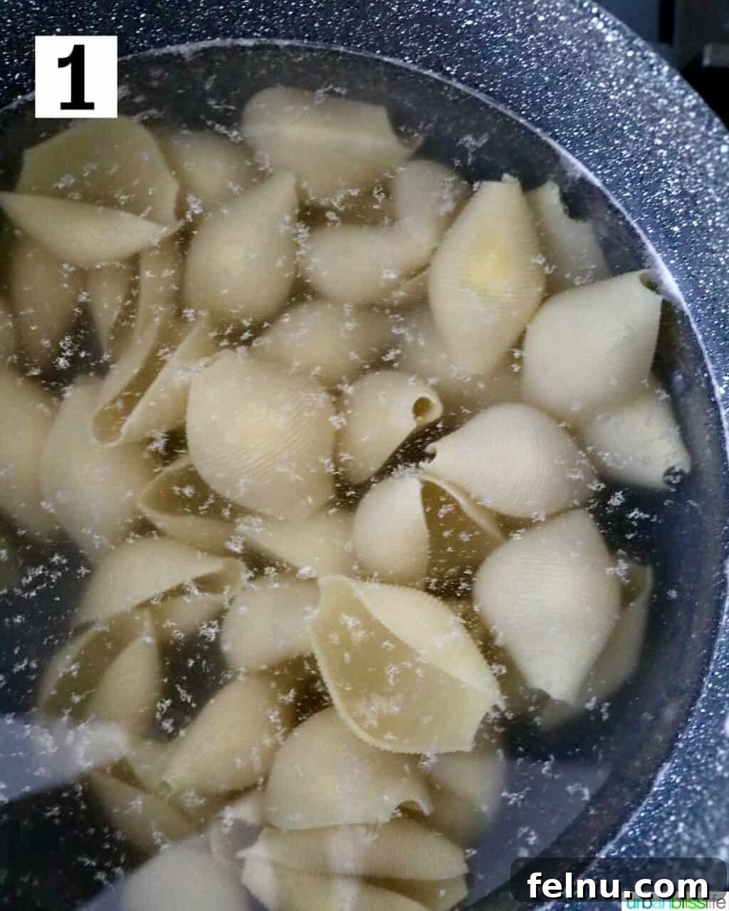Hearty Dairy-Free Beef Stuffed Shells 5 Jumbo pasta shells cooking in a large pot of boiling, salted water, preparing them for stuffing.