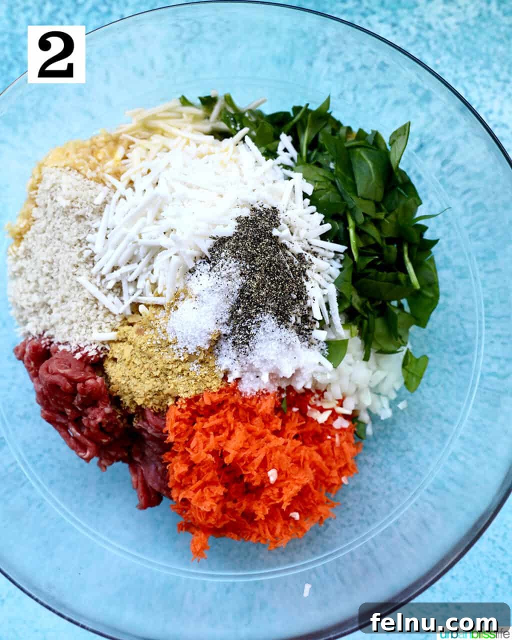 Hearty Dairy-Free Beef Stuffed Shells 6 A large bowl containing a vibrant mixture of ground beef, shredded carrots, chopped spinach, dairy-free cheese, herbs, and spices, ready for the shell filling.