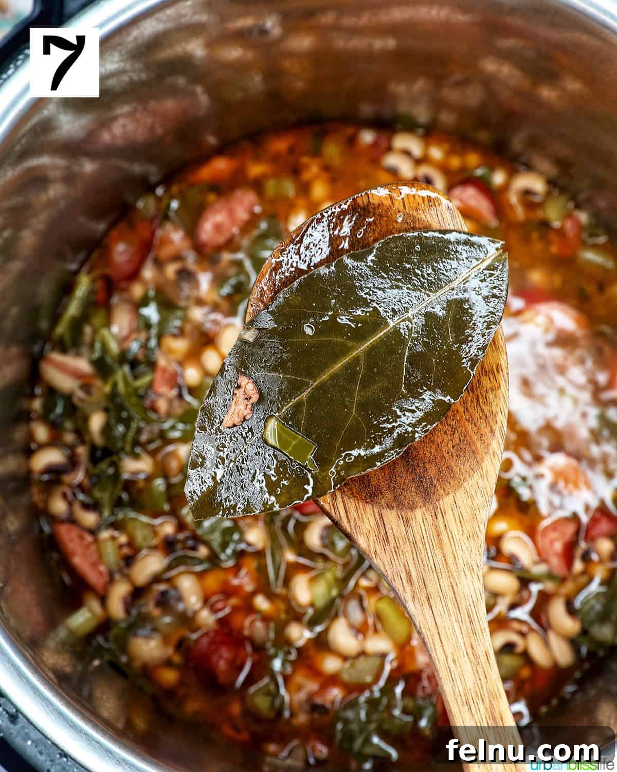 Quick Instant Pot Black Eyed Peas Soak Free 13 bay leaves on a wooden spoon above an Instant Pot of black eyed peas.