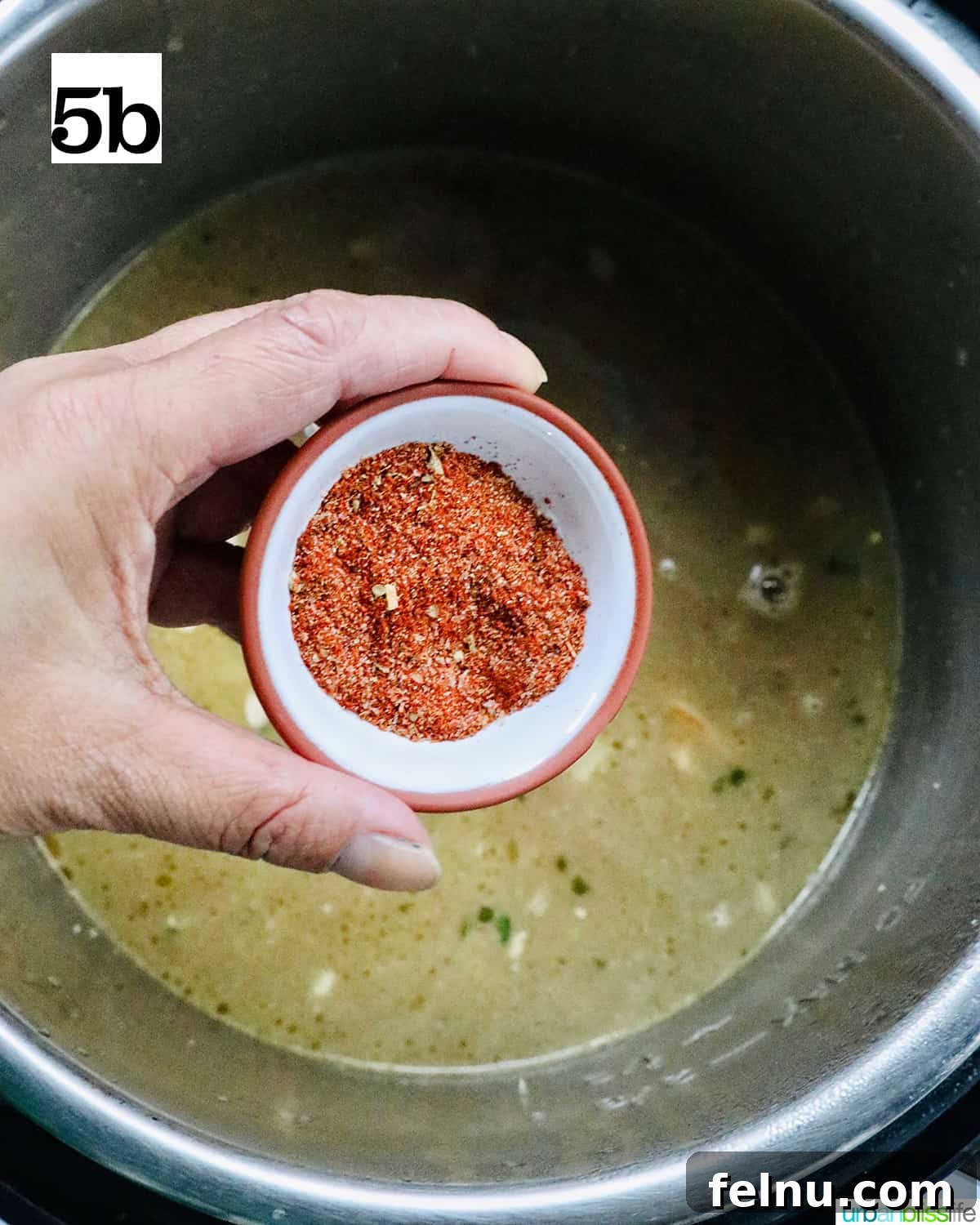 Quick Instant Pot Black Eyed Peas Soak Free 10 hand holding a small bowl of Cajun seasoning being added to the Instant Pot.