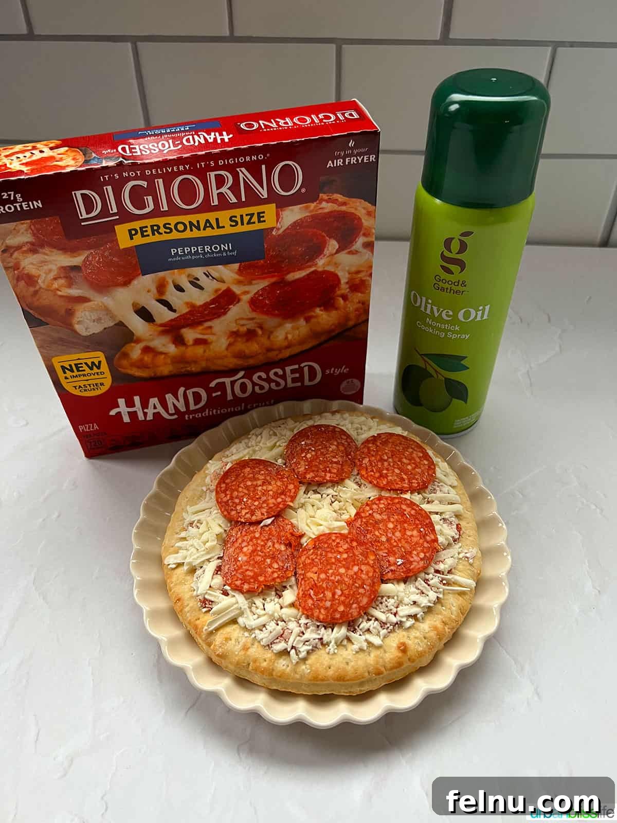 Air Fryer Pizza Perfection 4 Ingredients for air fryer frozen pizza, including a frozen pepperoni pizza and olive oil spray.