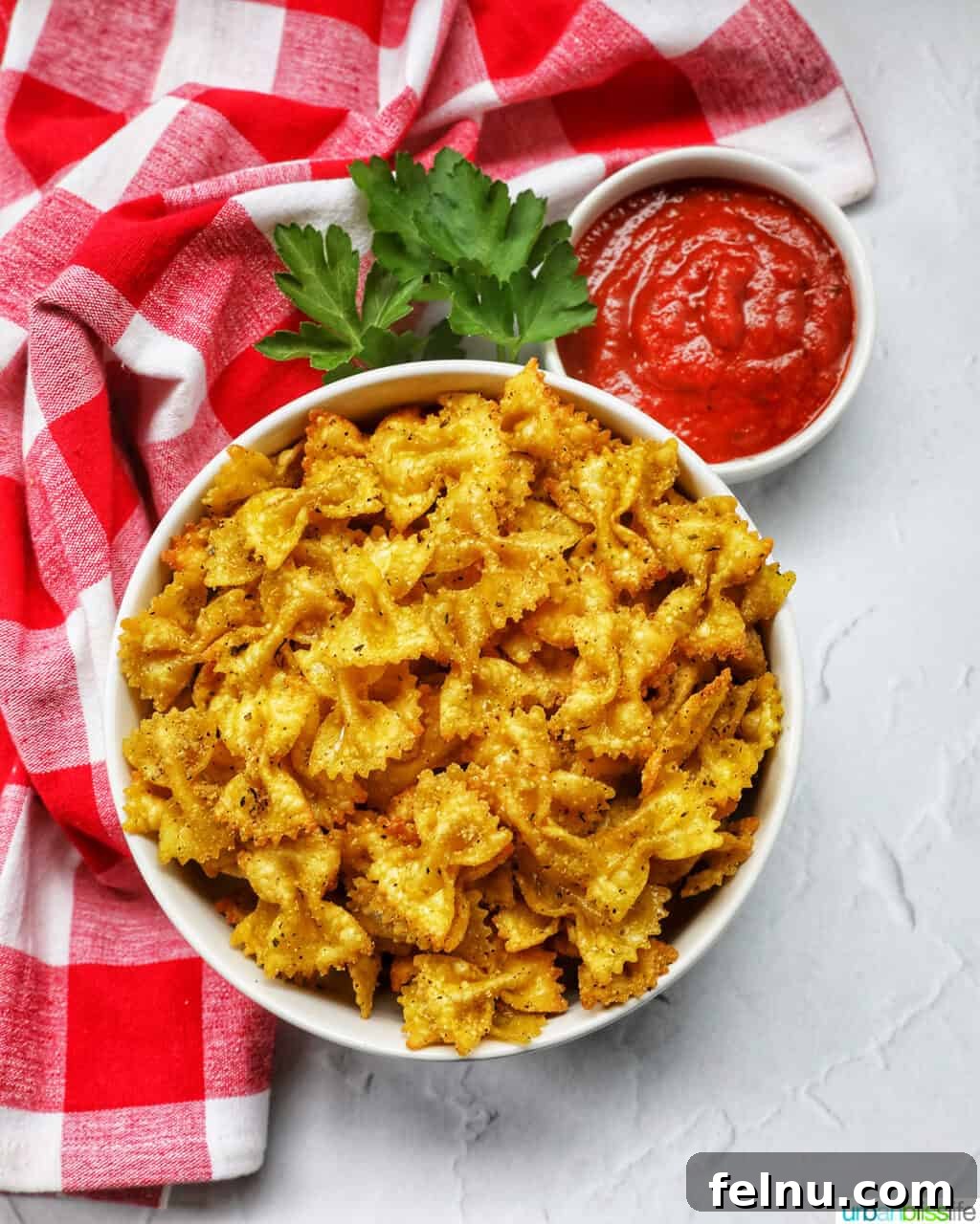 Air Fryer Pasta Chips
Crispy Air-Fried Pasta Snacks 3 Close-up of Air Fryer Pasta Chips served in a bowl with a red and white checkered napkin.