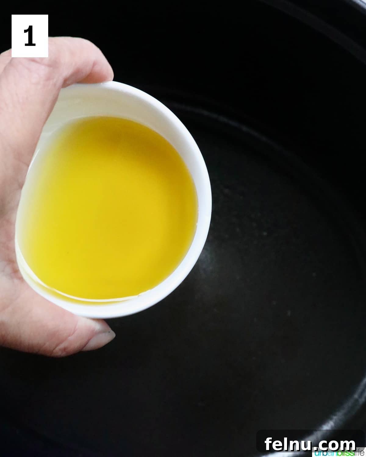 Chicken Minestrone Soup Delight 5 Hand pouring olive oil into a skillet, the first step in preparing the soup's base.