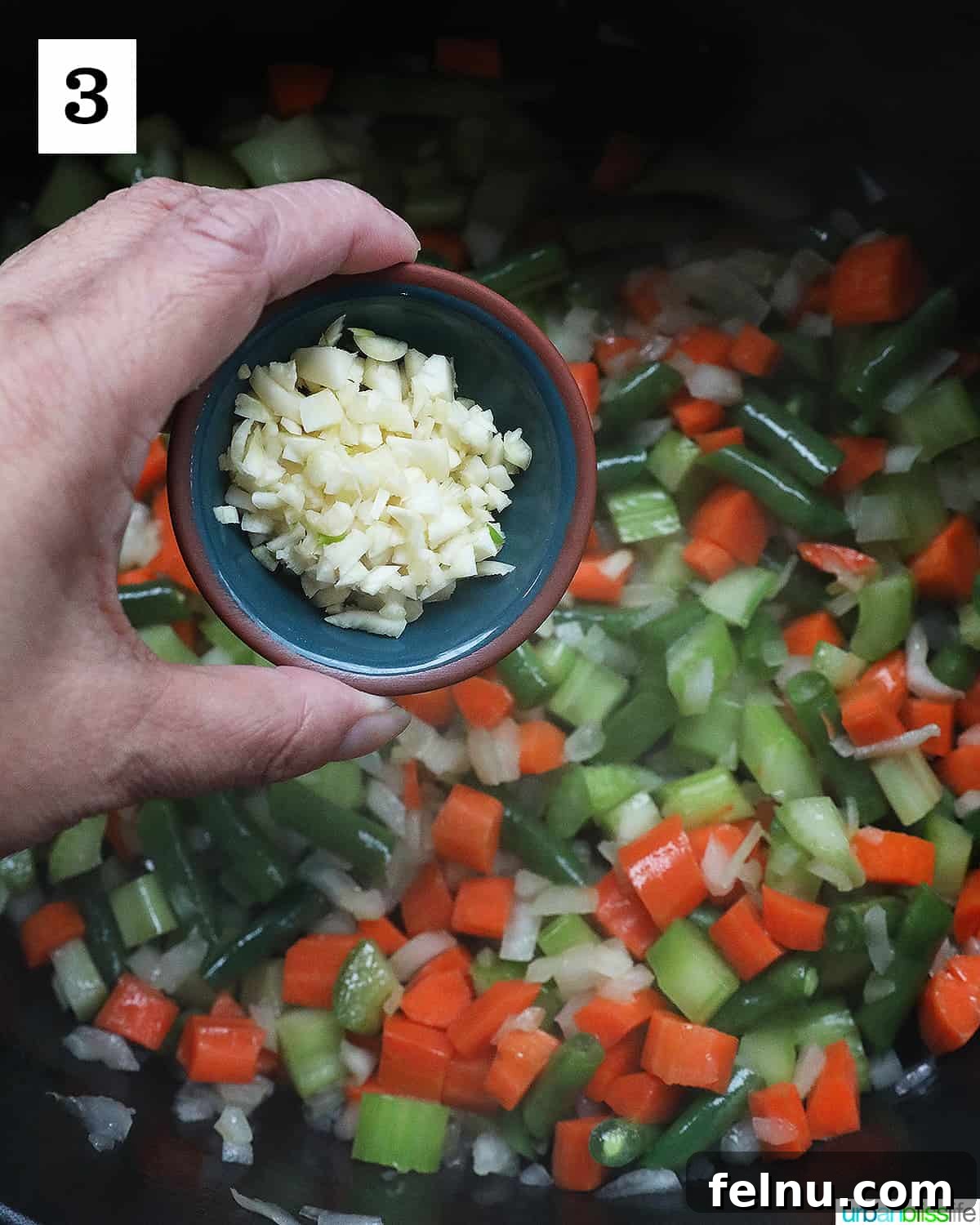 Chicken Minestrone Soup Delight 7 Minced garlic being added to sautéed vegetables, infusing the soup with its pungent aroma.