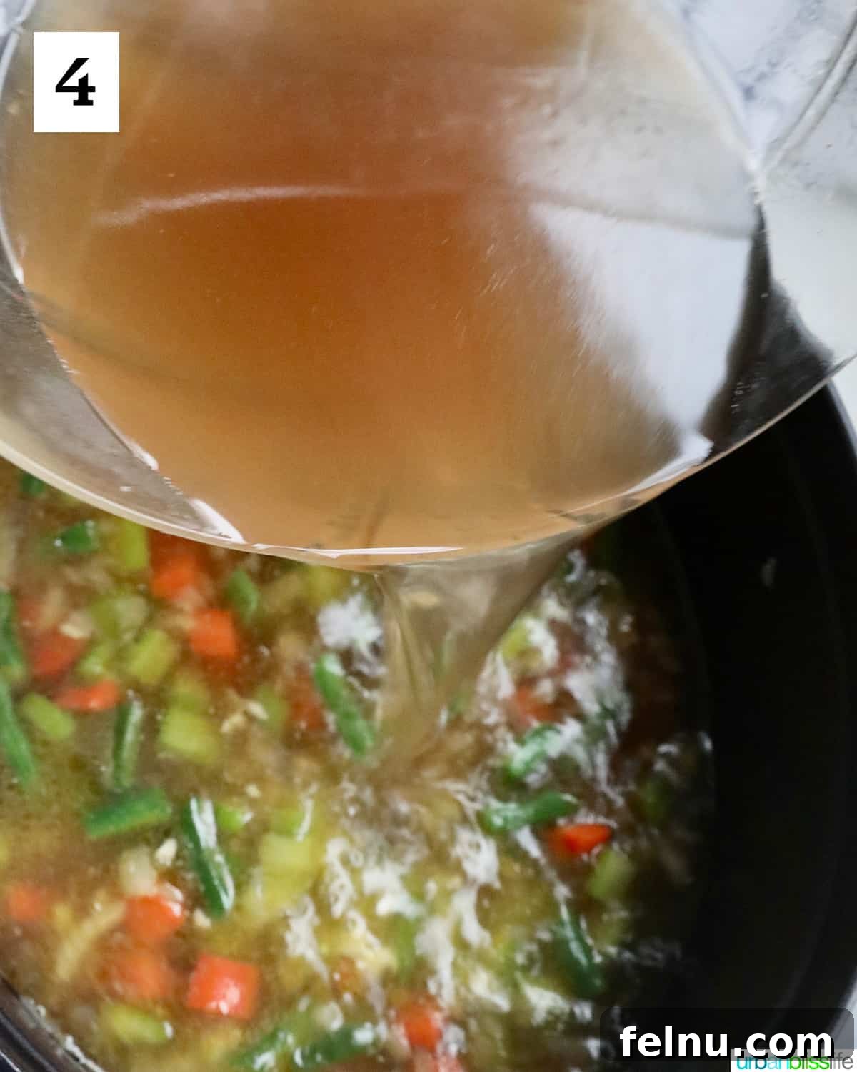 Chicken Minestrone Soup Delight 8 Broth being poured into a pot of Chicken Minestrone Soup, setting the stage for simmering and developing the soup's rich flavors.