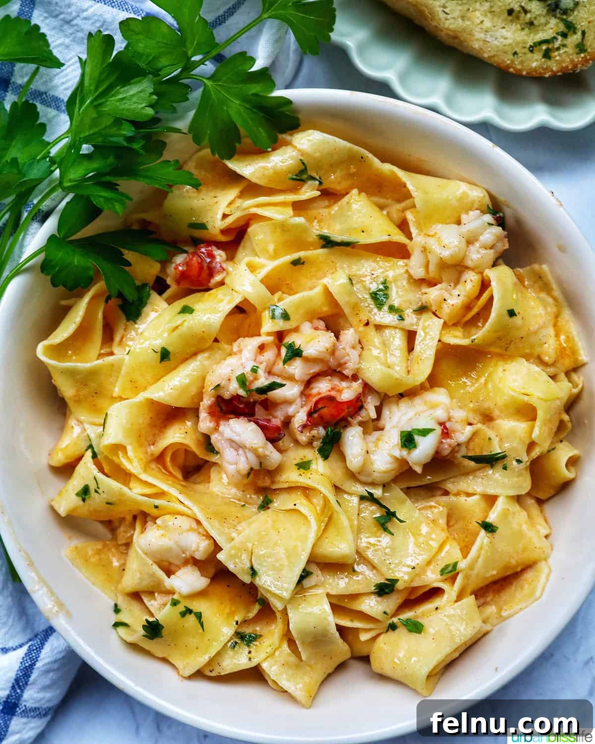 Luxurious Lobster Pasta 2 bowl of lobster pasta with side of parsley, ready to be enjoyed.