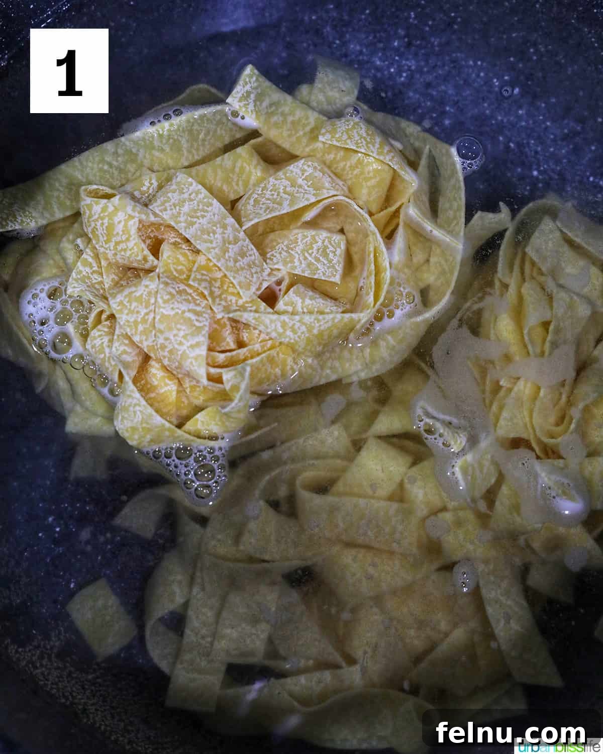 Luxurious Lobster Pasta 5 pappardelle pasta being added to a pot of boiling water.