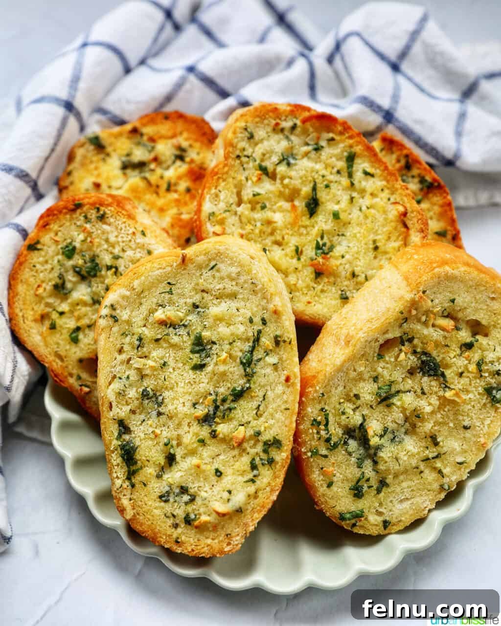 Air Fryer Garlic Toast 2 Golden brown slices of air fryer garlic bread on a plate.