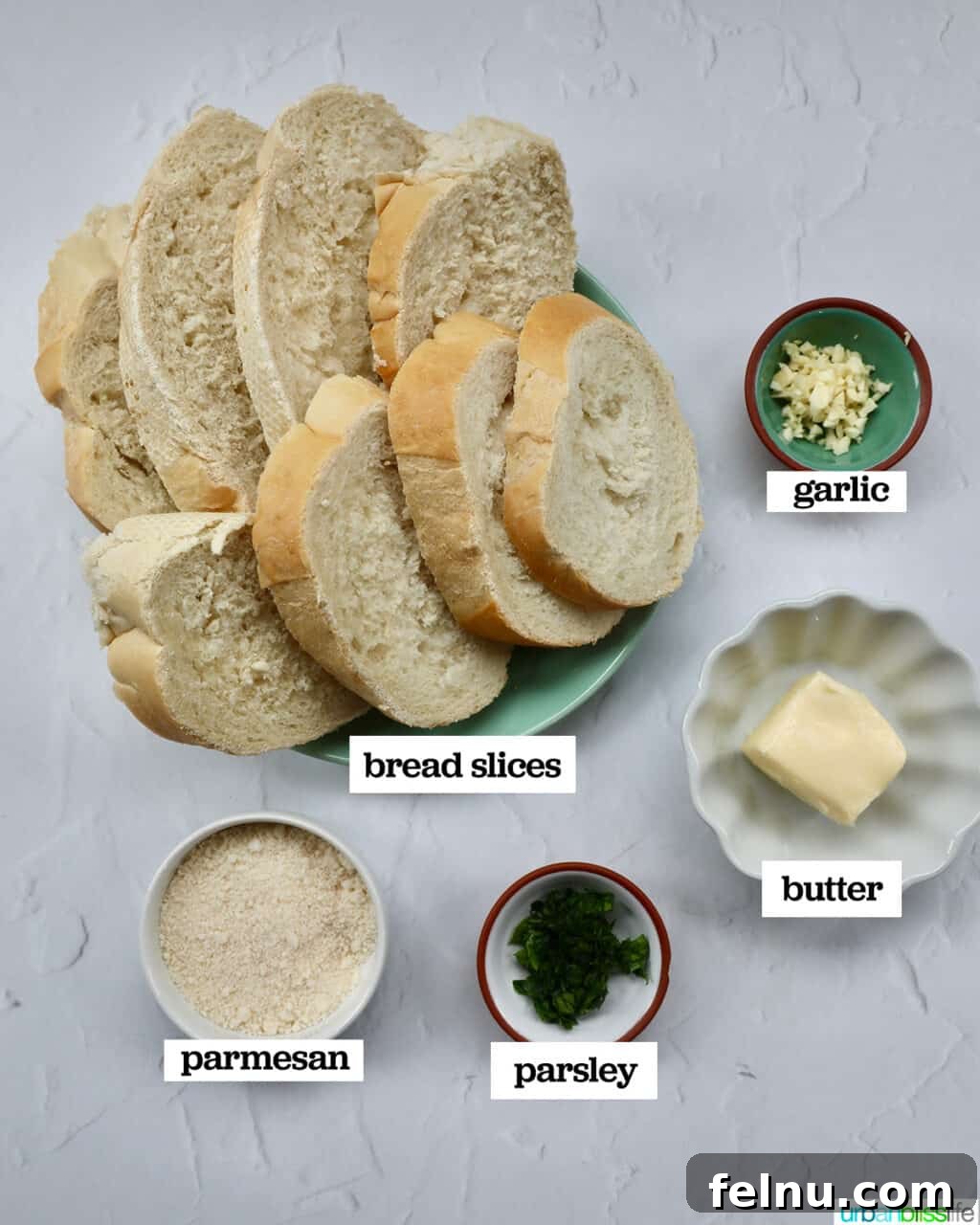 Air Fryer Garlic Toast 4 Ingredients for air fryer garlic bread: French bread, butter, garlic, parsley, and parmesan cheese.