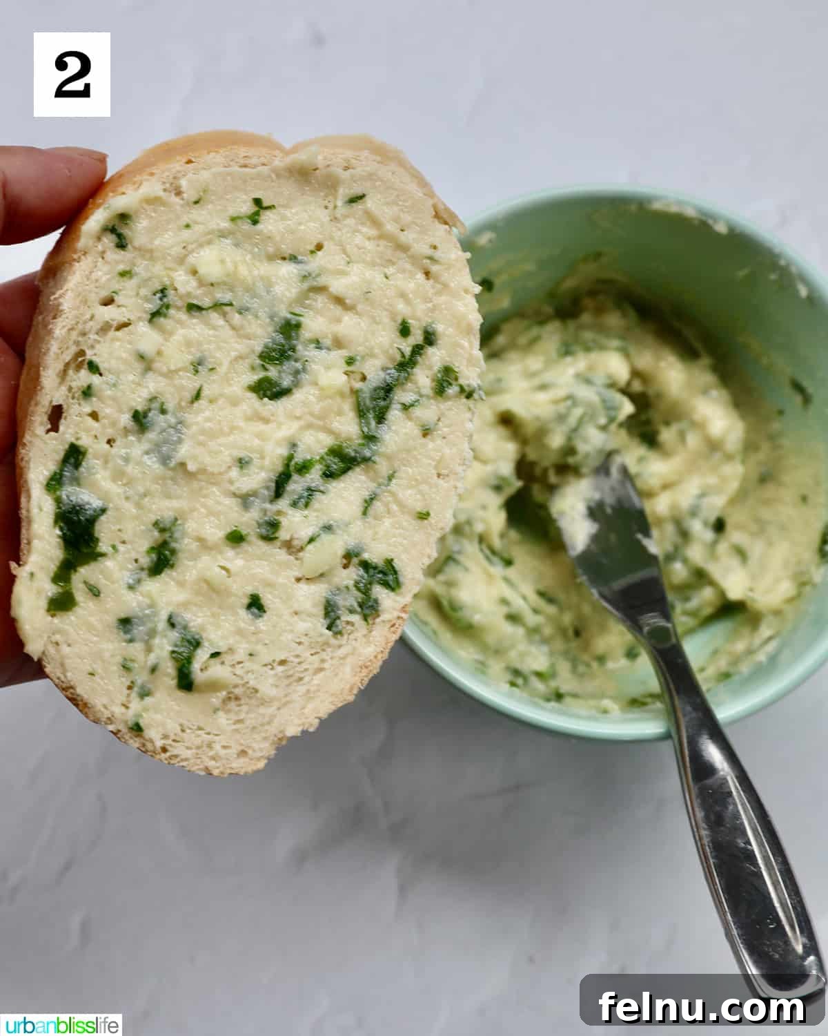 Air Fryer Garlic Toast 7 Spreading garlic butter on a slice of French bread.