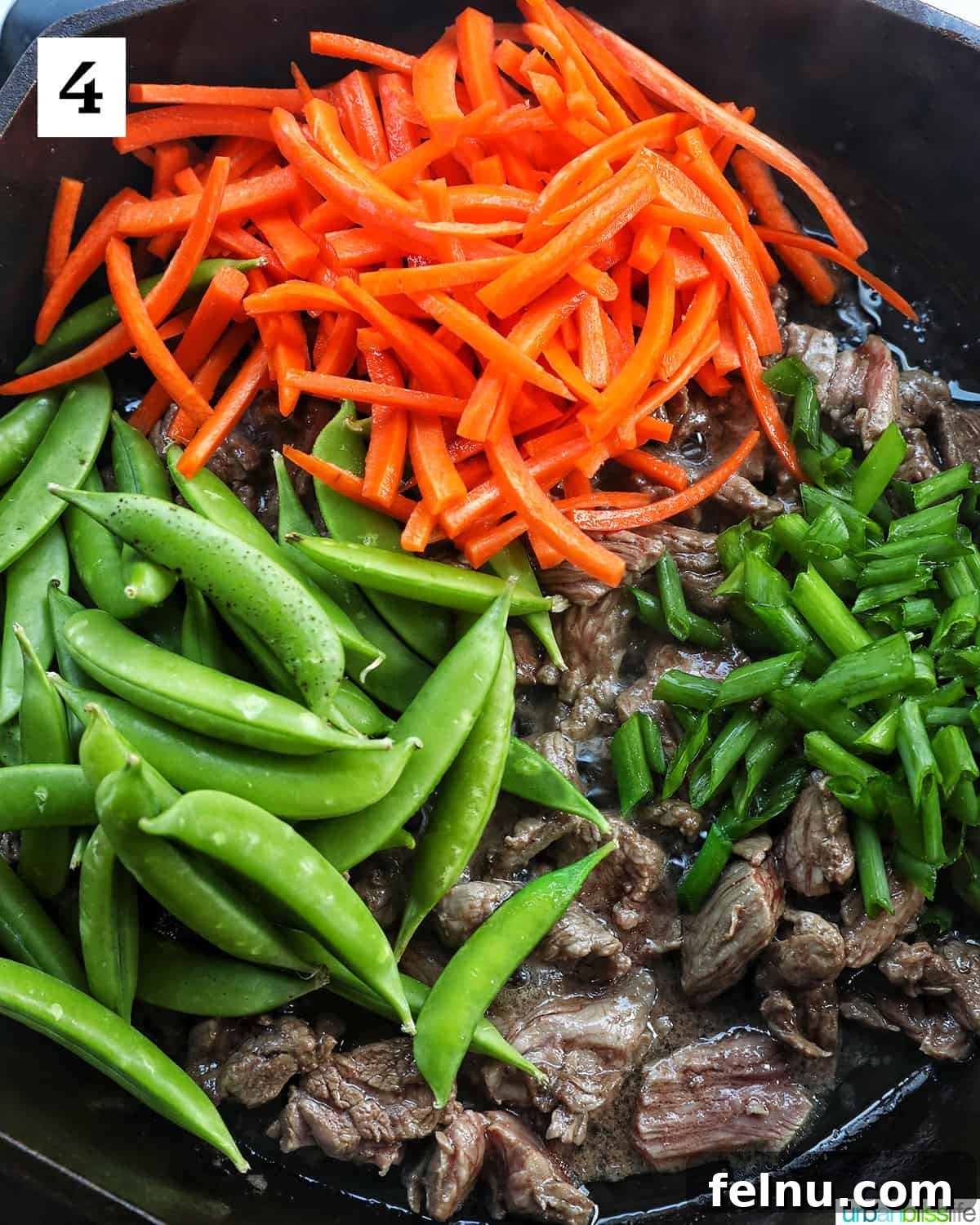 Beef Pad Thai 9 Snap peas, carrots, scallions, and steak in a cast iron skillet.