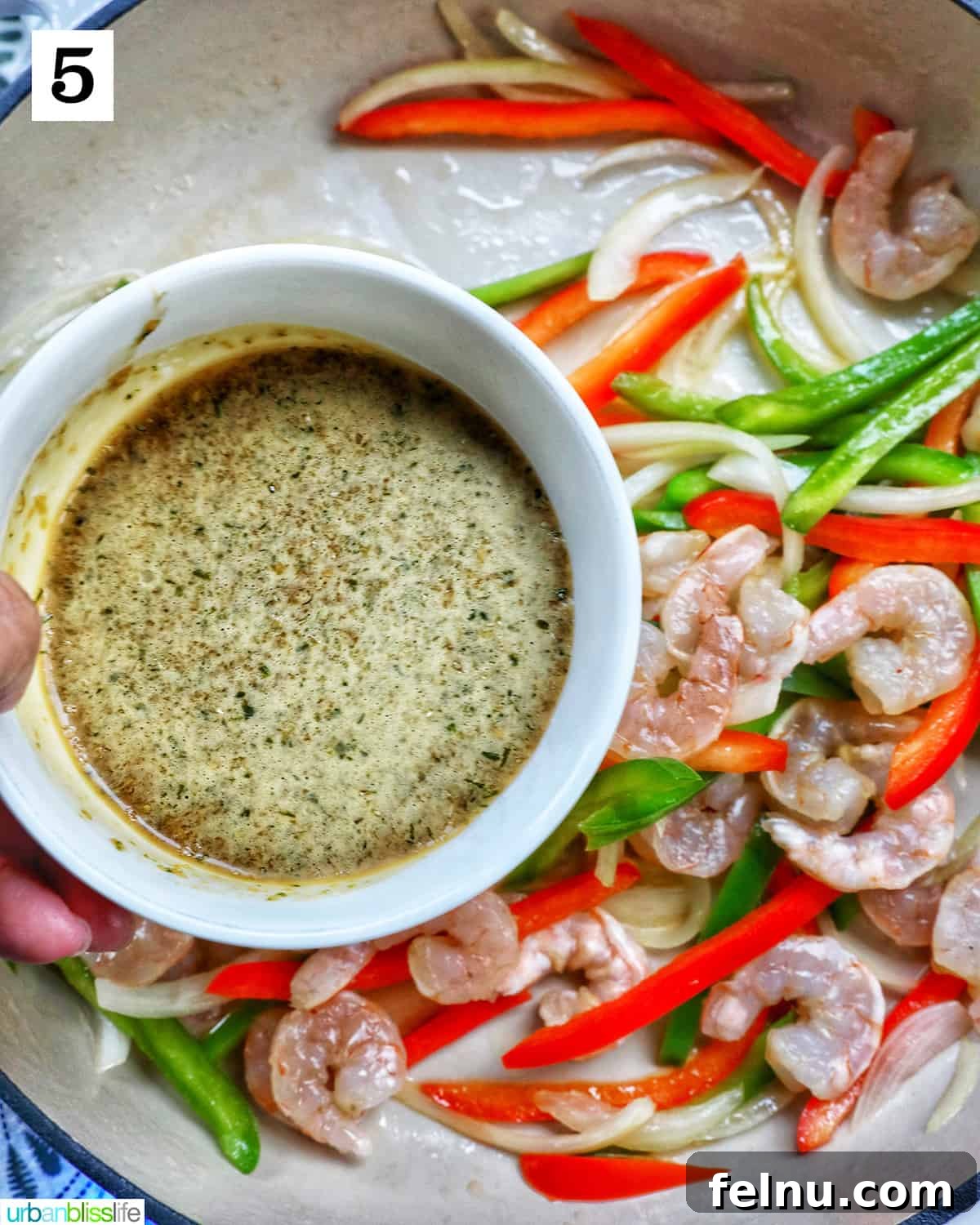 Thai Basil Prawn Stir-Fry 10 Pouring the prepared sauce over the shrimp and vegetables.
