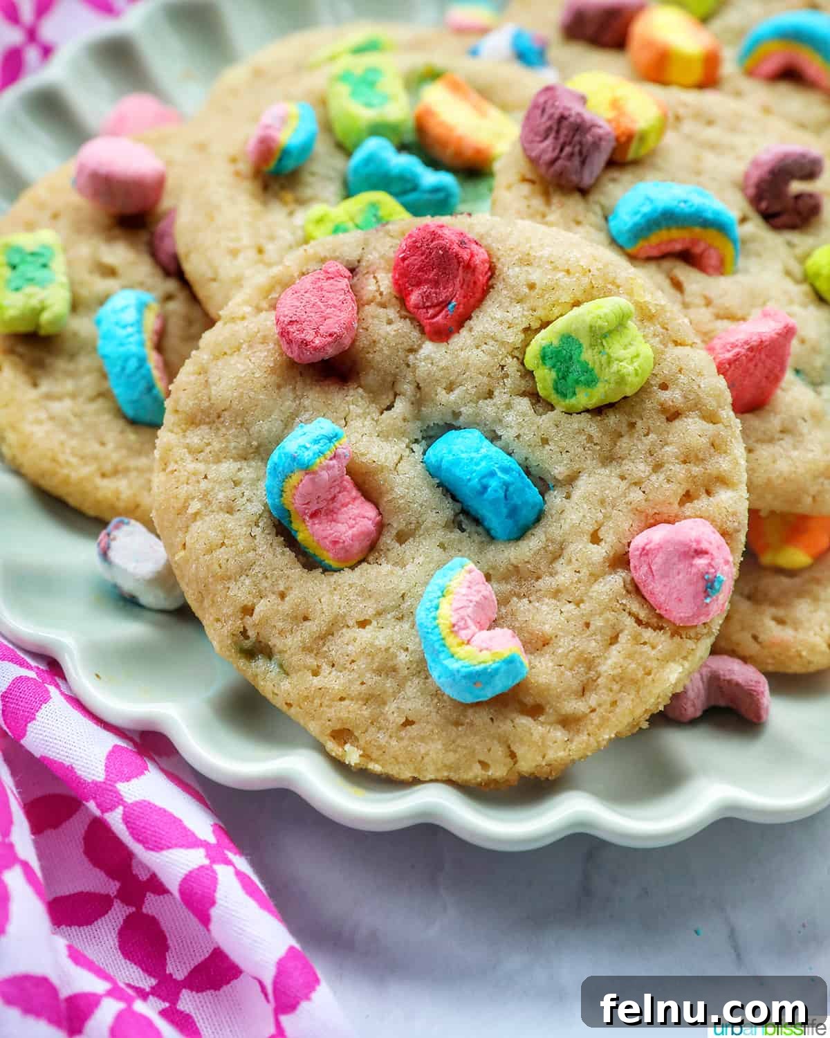 Lucky Charms Cookies 2 Lucky Charms Cookies stacked on a plate, showcasing colorful marshmallows.