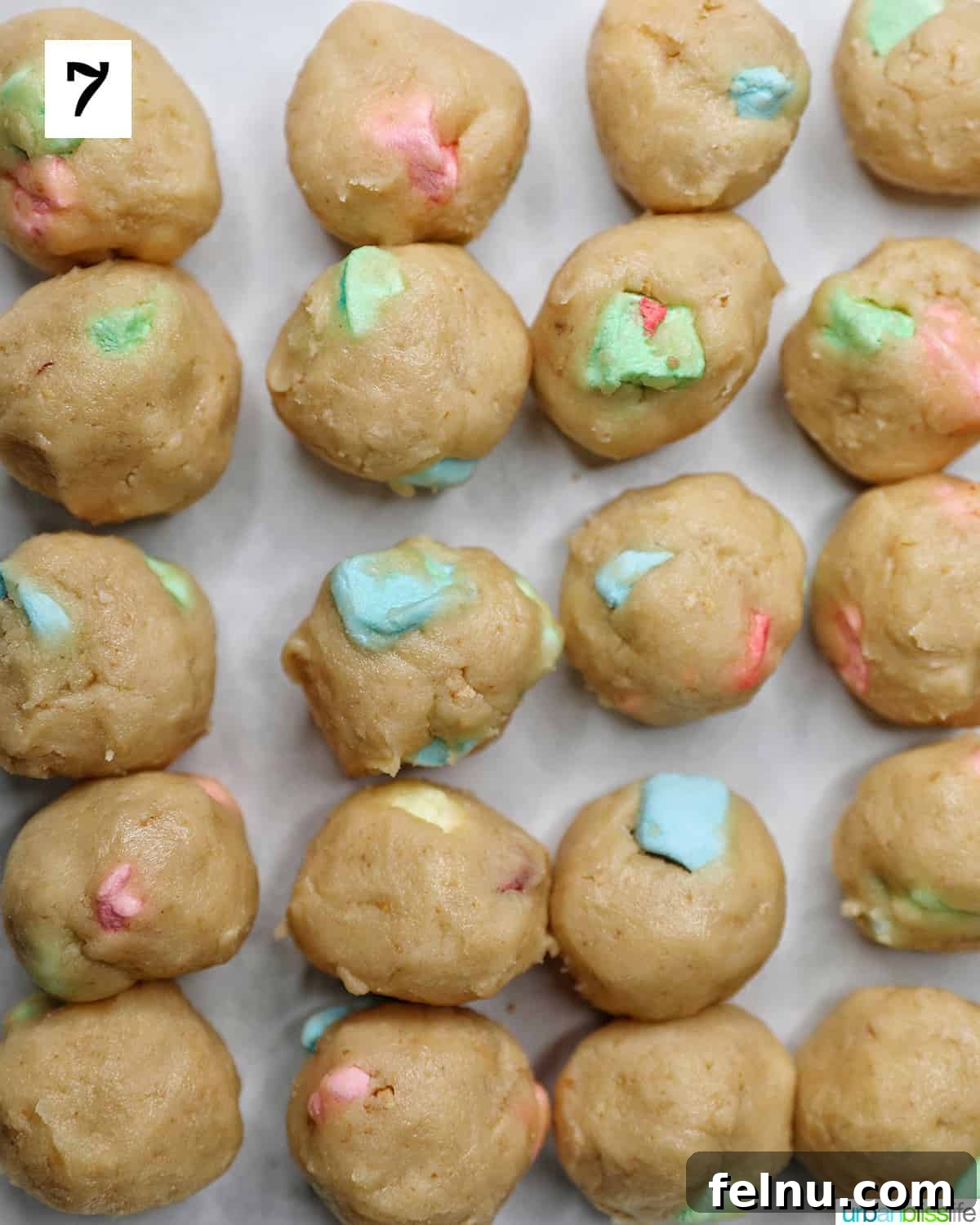 Lucky Charms Cookies 12 Cookie dough balls on a baking sheet.