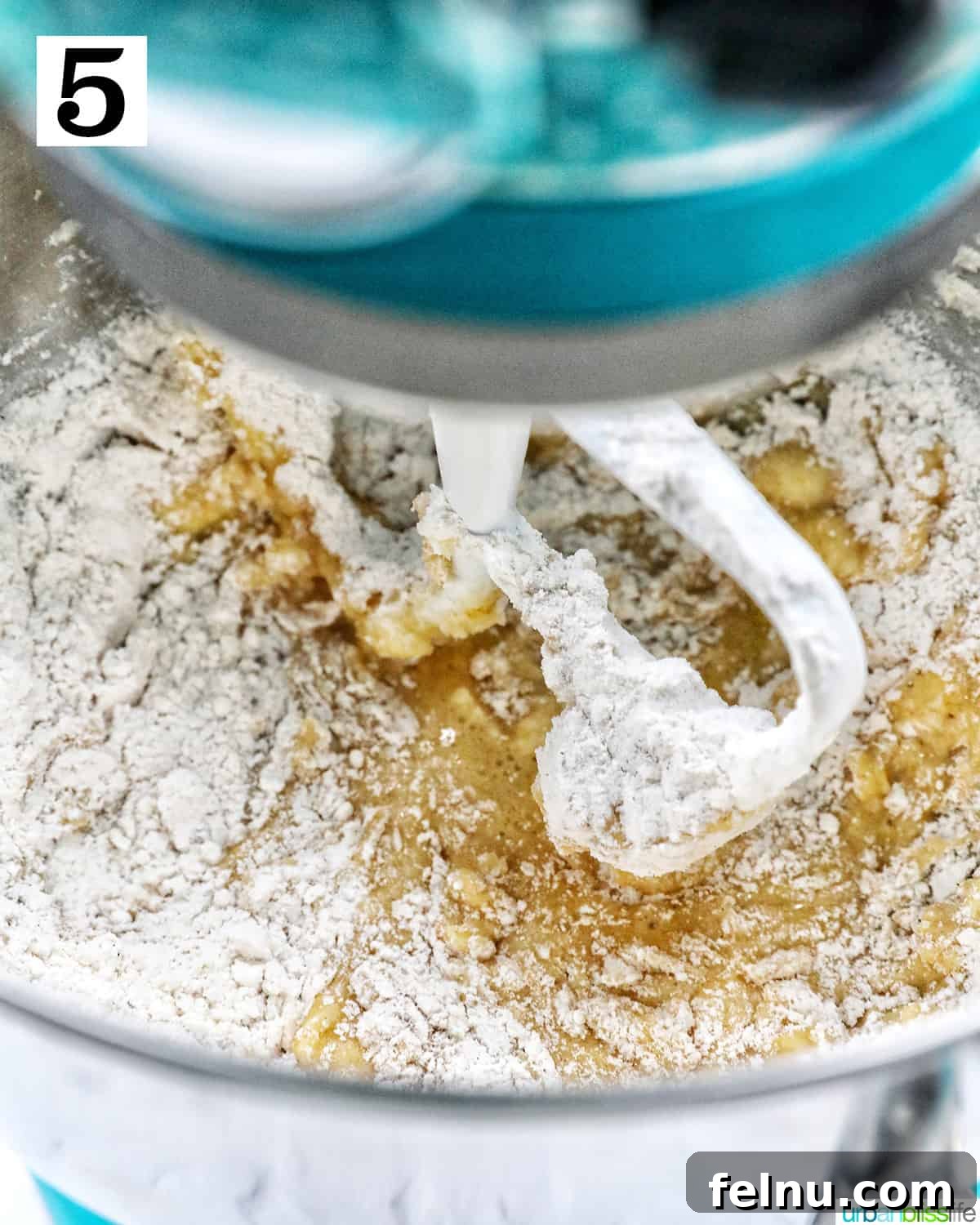Emerald Isle Coffee Cake 12 Dry ingredients being gently added to the wet mixture in a stand mixer, initiating the blending process for the Irish coffee cake batter.