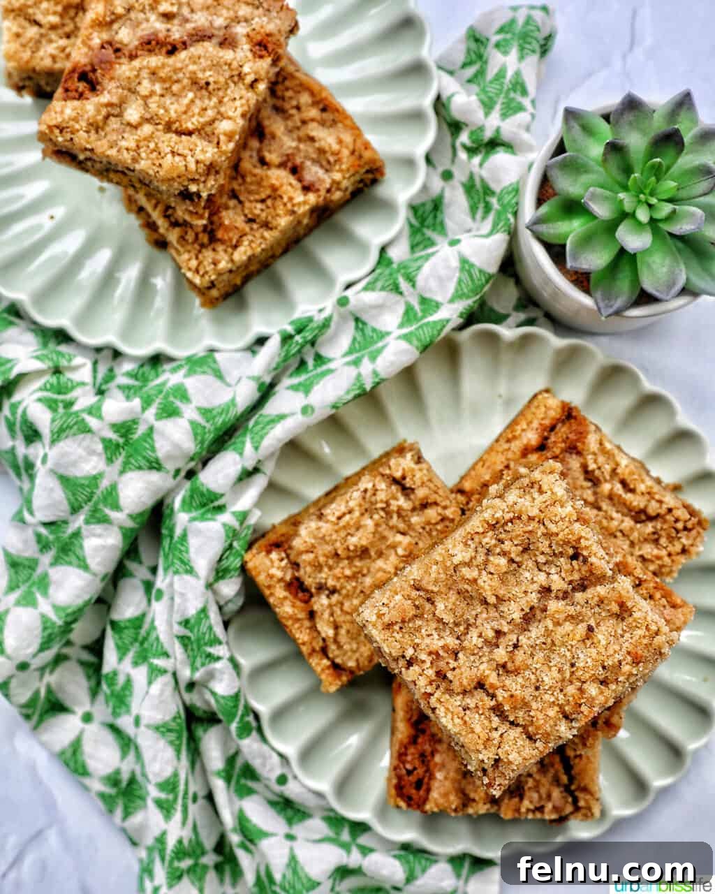 Emerald Isle Coffee Cake 3 Two enticing stacks of Irish coffee cake presented on green plates, adorned with festive green patterned napkins and a lush green plant, creating a beautiful and appetizing scene.