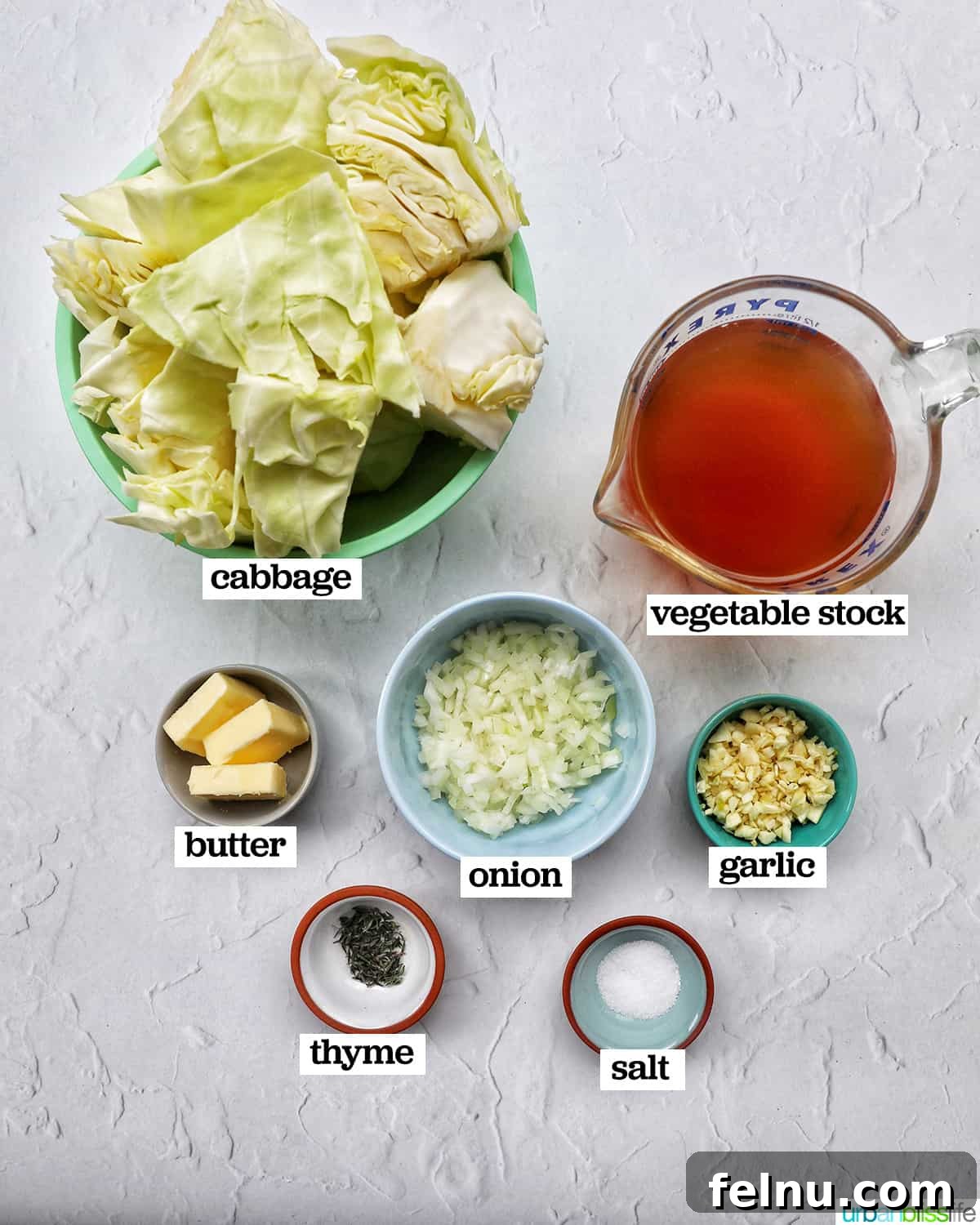 Effortless Instant Pot Cabbage 4 Individual bowls holding the fresh ingredients for Instant Pot Cabbage: chopped green cabbage, minced garlic, diced yellow onion, and a stick of butter.