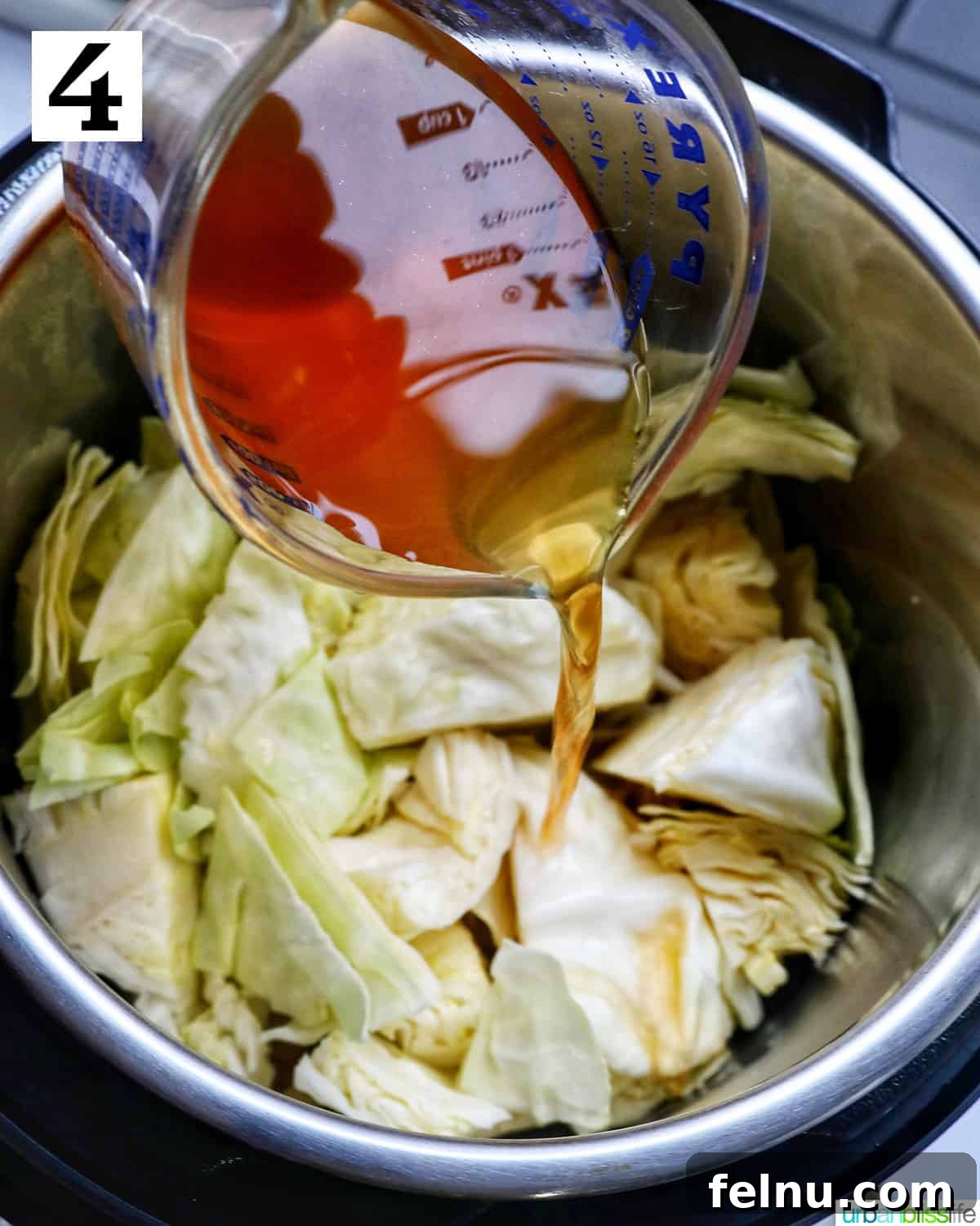 Effortless Instant Pot Cabbage 8 Vegetable stock being poured over the seasoned aromatics in the Instant Pot, deglazing the pot.