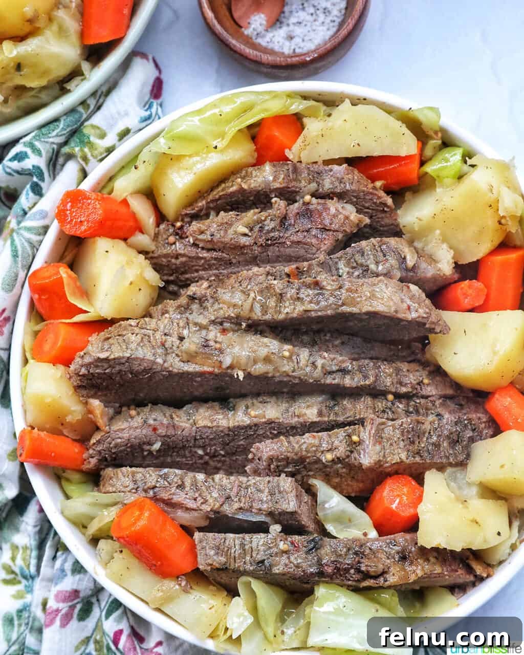Tender Dutch Oven Brisket 2 bowl of sliced dutch oven brisket with carrots, potatoes, and cabbage.