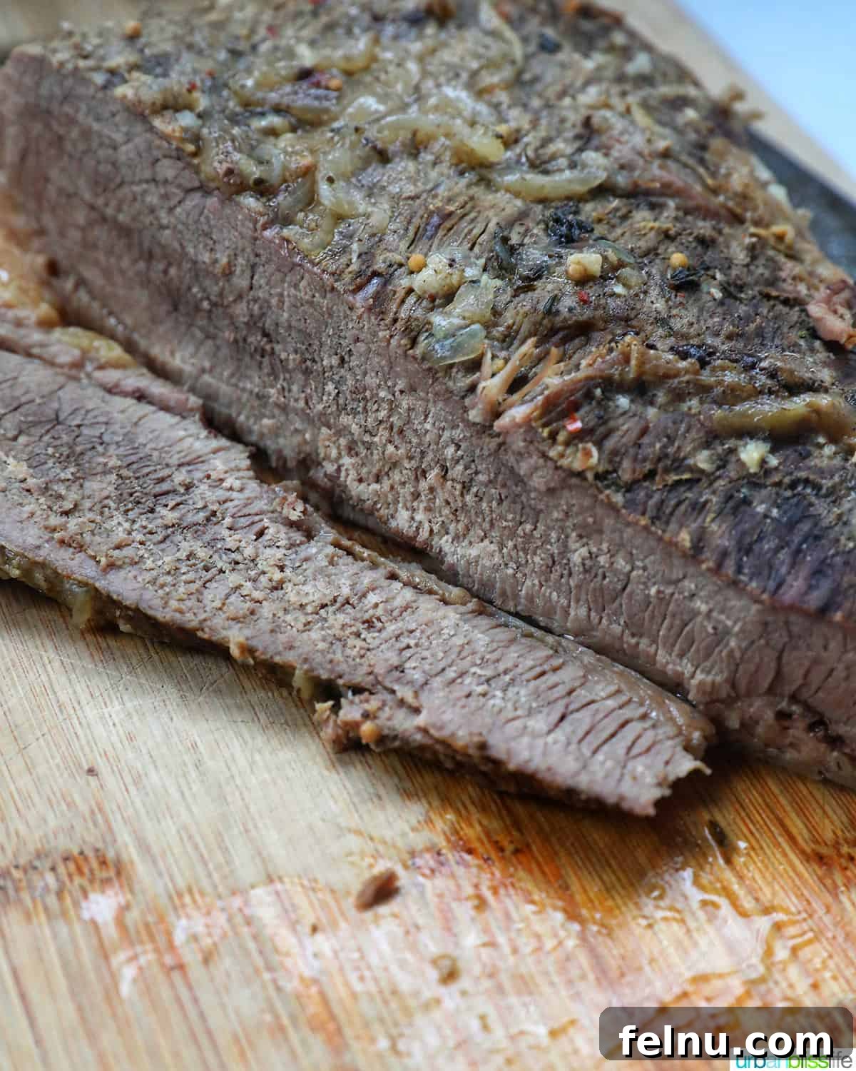 Tender Dutch Oven Brisket 15 sliced brisket cooked in a dutch oven on a cutting board.