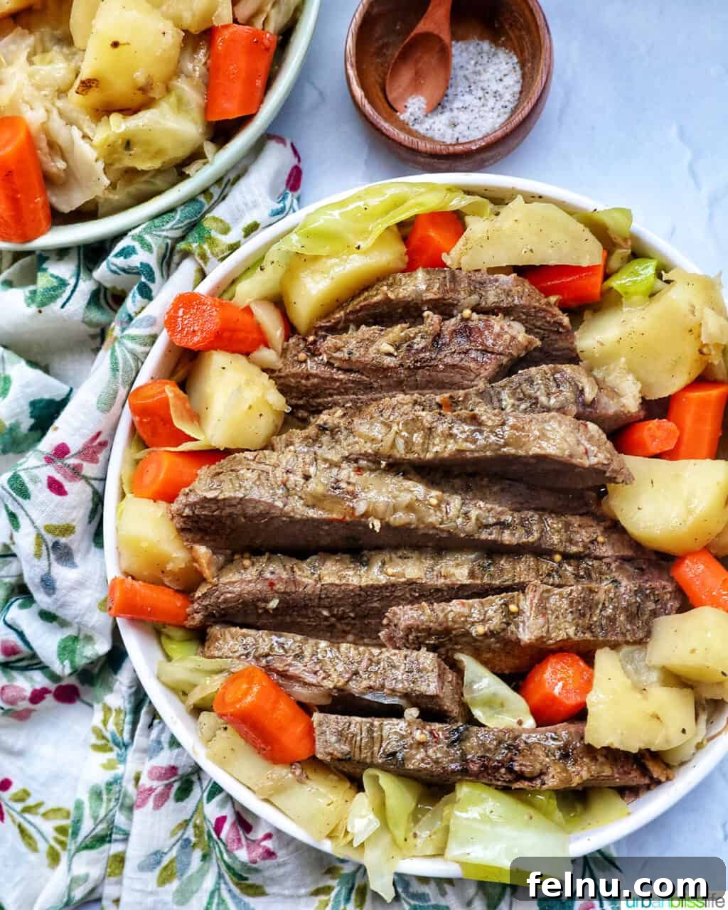 Tender Dutch Oven Brisket 16 bowl of sliced dutch oven brisket with carrots, potatoes, and cabbage.