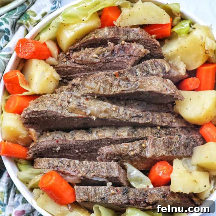 Tender Dutch Oven Brisket 17 bowl of sliced dutch oven brisket with carrots, potatoes, and cabbage.