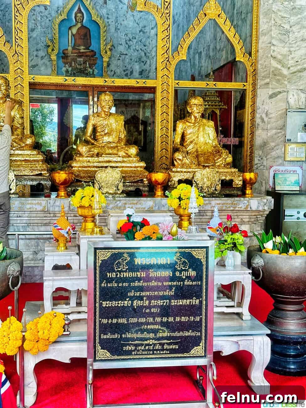 Wat Chalong Temple: A Spiritual Journey in Phuket 18 The grand hall of Wat Chalong, adorned with golden statues and informational signs.