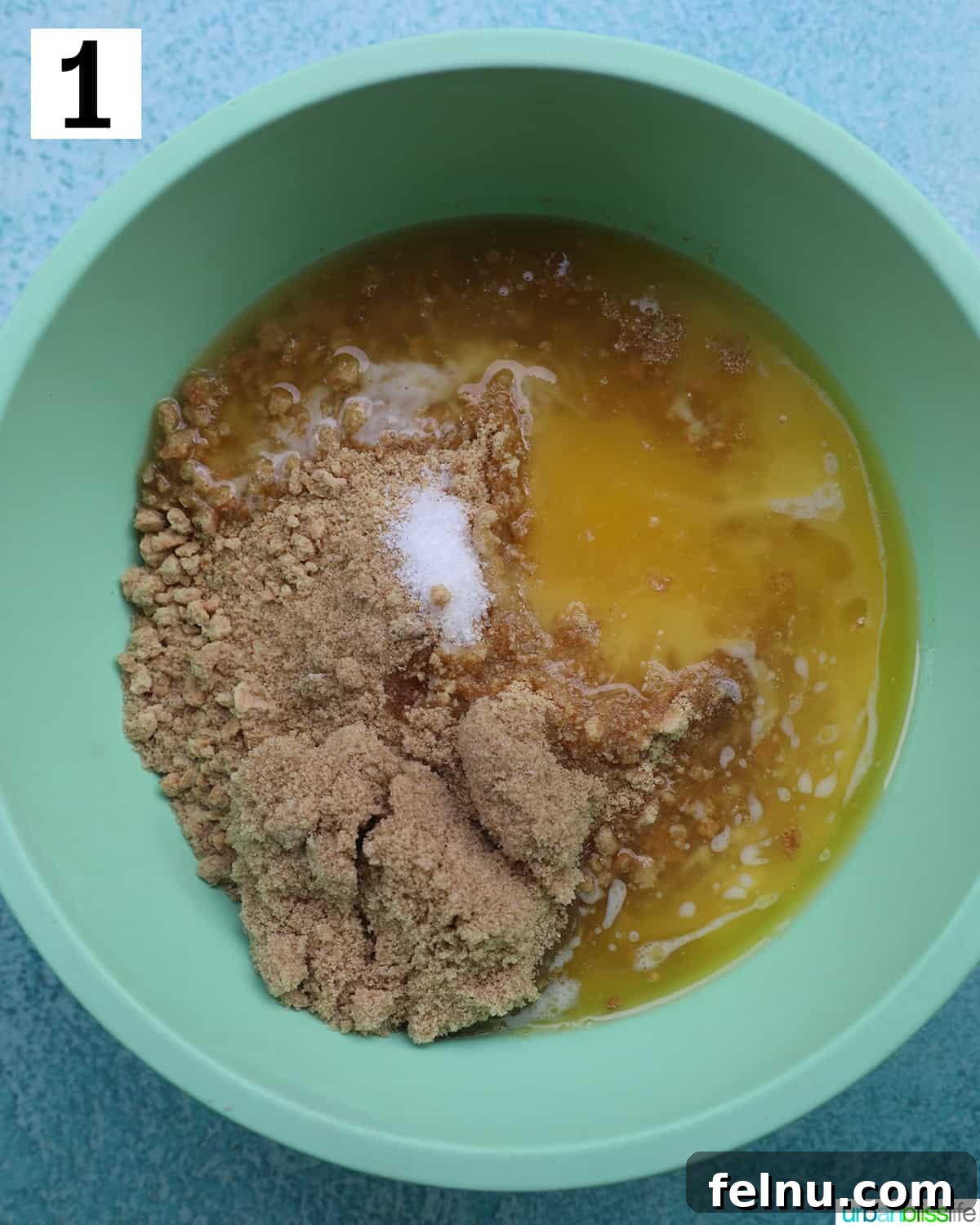 Easter Egg Delight Cheesecake 10 Mixing the crust ingredients in a green bowl.