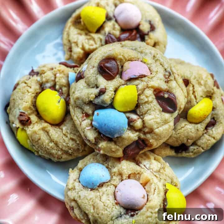 A stack of cheerful Easter mini egg cookies on a pink scalloped plate, highlighting their festive colors.