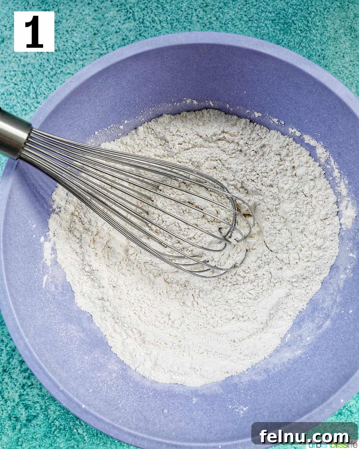 Effortless Mini Egg Cookies 6 A large bowl containing mixed dry ingredients for mini egg cookies, showcasing the flour, baking powder, baking soda, cornstarch, and salt.