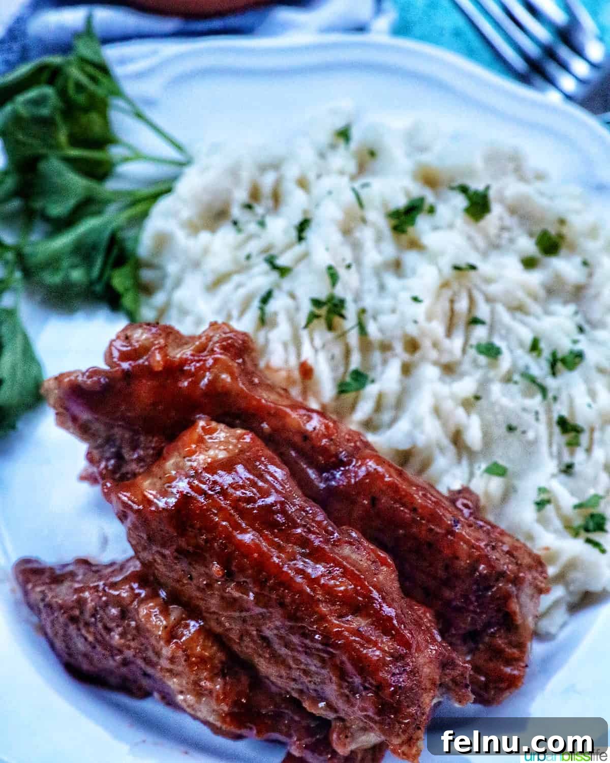 Instant Pot country style ribs served with mashed potatoes and herbs.