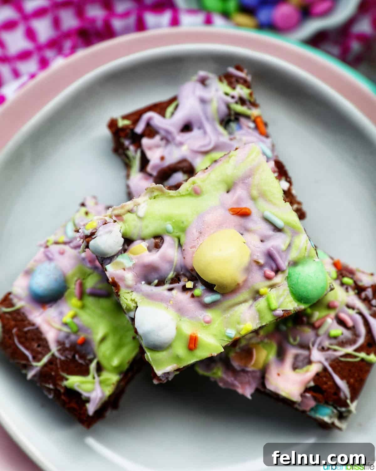 Easter Chocolate Squares 2 A delectable stack of colorful Easter brownies arranged on a white and pink plate.
