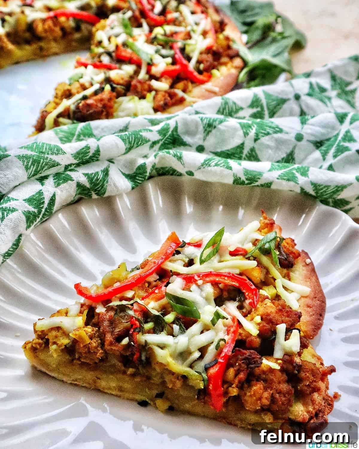 Thai Curry Pizza Delight 12 Slice of Thai curry pizza on a plate next to an almost full pizza