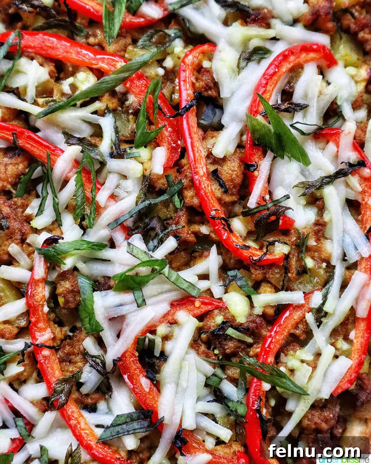 Thai Curry Pizza Delight 3 Close-up of Thai curry pizza toppings with sliced red peppers, fresh basil, and dairy-free mozzarella