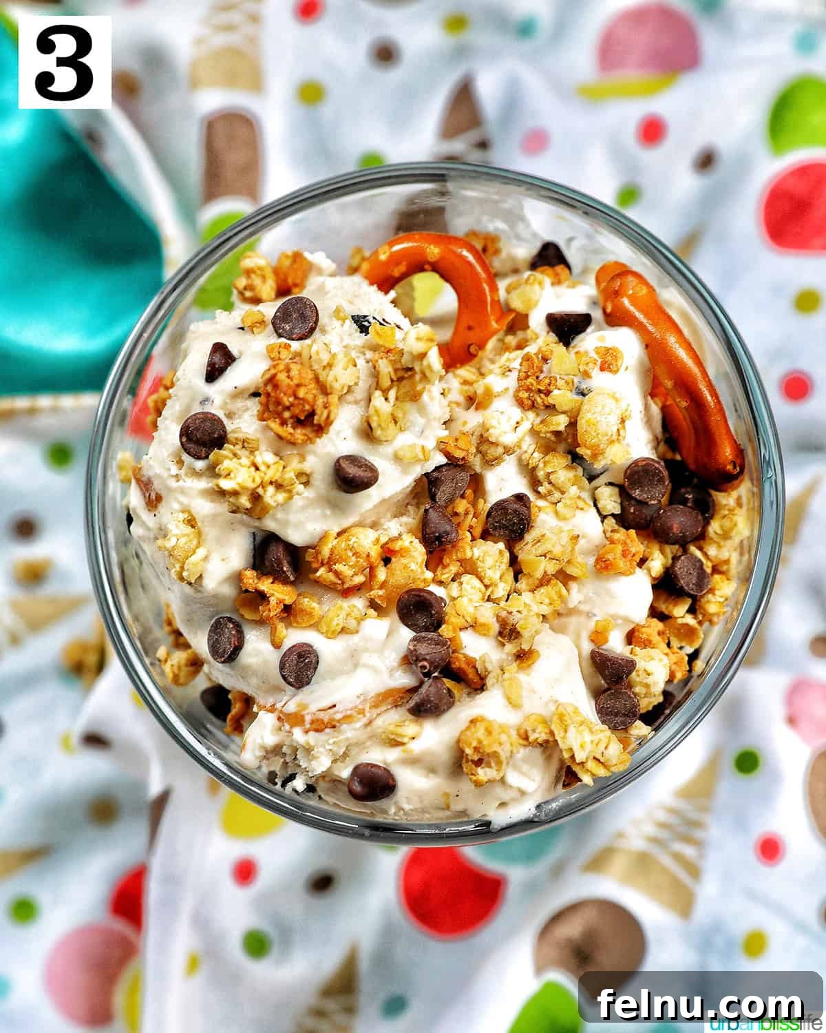Ice Cream Parfait: A Symphony of Flavors and Textures 7 An ice cream parfait, adorned with granola and mini chocolate chips, showcased on a colorful kitchen towel.