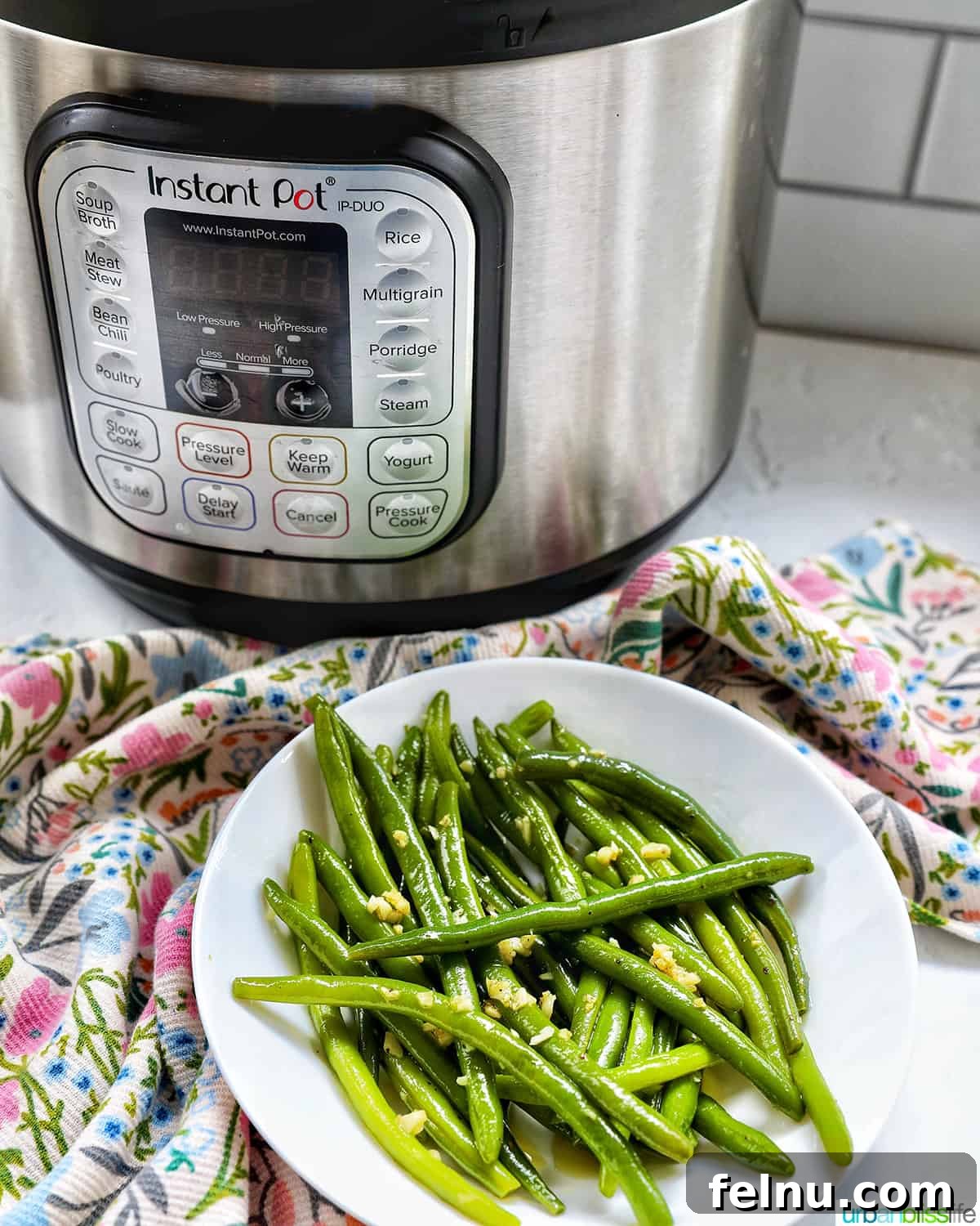 Instant Pot Green Beans in a white bowl with an Instant Pot in the background, highlighting the convenience of this cooking method.