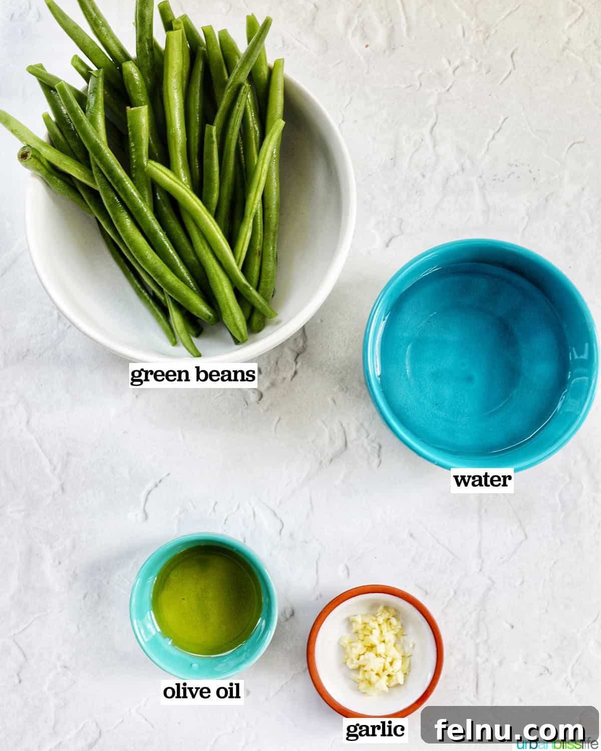 Bowls of ingredients for Instant Pot Green Beans, including fresh green beans, olive oil, garlic, and water.